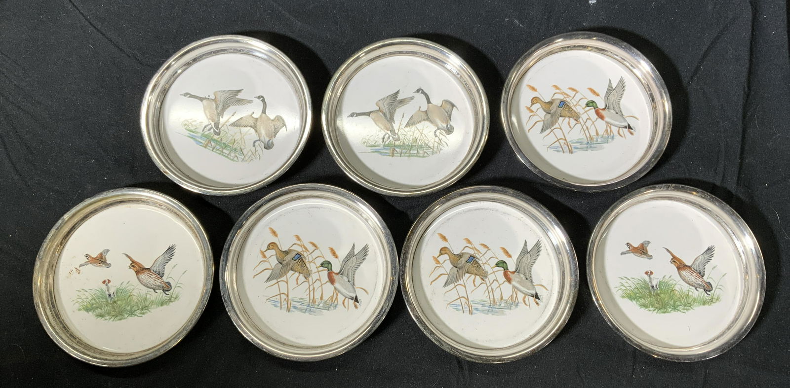 Lot 7 FB ROGERS Vintage Bird Coasters: Set of 7 vintage FB ROGERS SILVER CO bird coasters featuring various types of birds. Surface wear consistent with age, use, and exposure. Measures approx. 4 inches wide. Signed and trademarked with cr