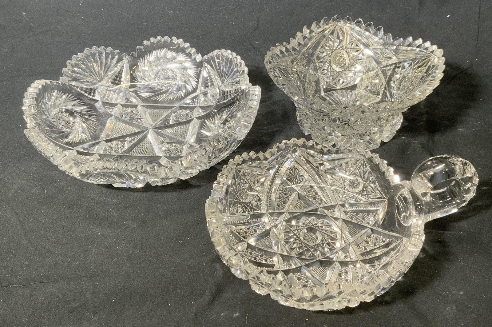 Lot 3 Saw Tooth Cut Crystal Bowls: Lot of 3 cut crystal bowls. Various sizes. Largest measures 8 inches diameter and 1.75 inches tall, taller bowl measures approx. 6 inches diameter and 2.75 inches tall, bowl with handle measures appro