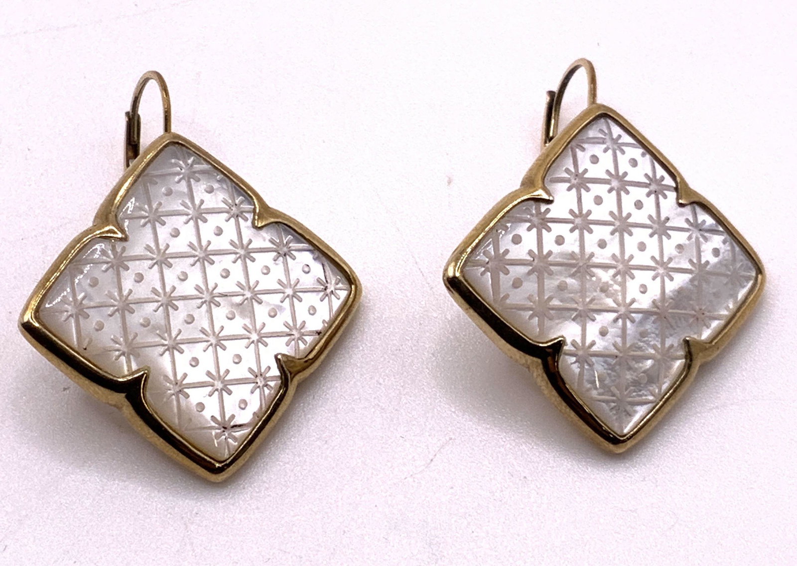 SIGNED luxury Designer Mother of Pearl Earrings: Signed Luxury designer medallion earrings with bezel set mother of Pearl on center with engraved patterned design set in 14KGF metal. Lever back closure. Signed by designer on earring back, illegible,