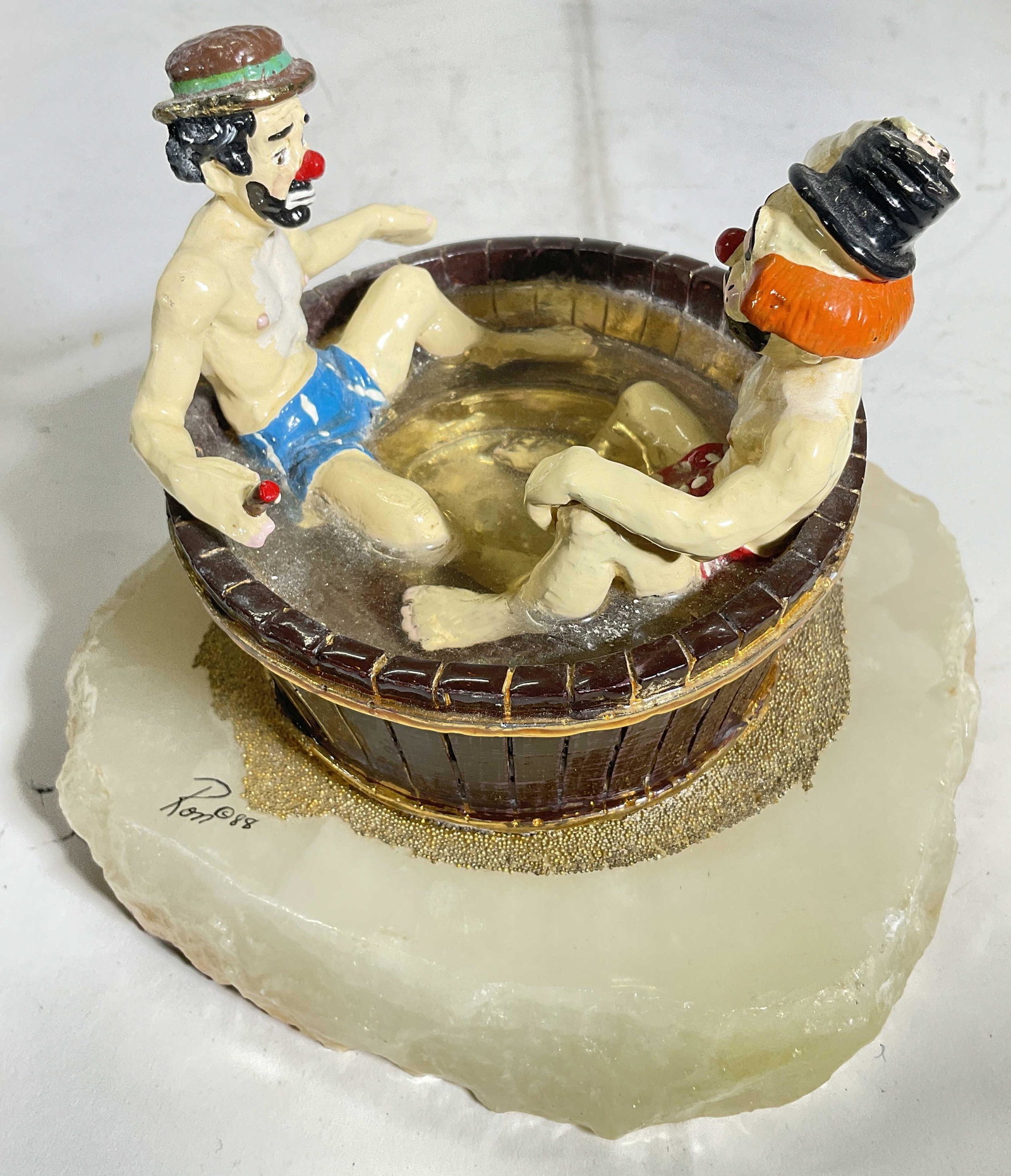 Signed Clowns In Tub Decorative Sculpture: Signed clowns in tub. Significatn weight. Piece is mixed materials and appears to include ceramic, metal, resin and onyx, Signed Ron 88 . Measures approx 7W x 5.5 inches. Surface wear to piece consist