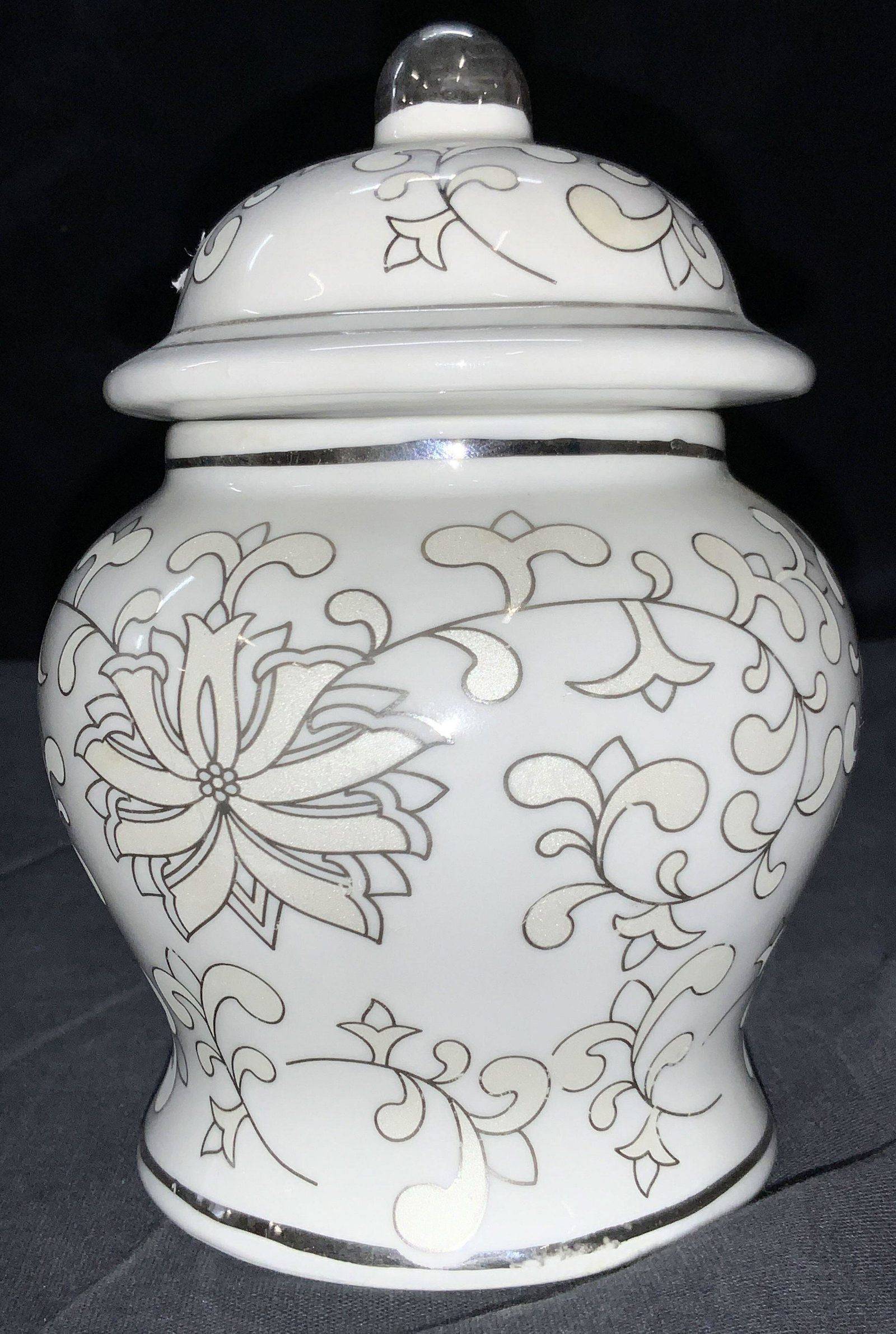 L.F.LIMOGES Fine Porcelain Ginger Jar: A white porcelain ginger jar with lid. A rounded body with exterior scroll and floral designs with silver toned outlines. Approximately 7 inches tall. Marked on underside Hand Crafted Fine Porcelain, 