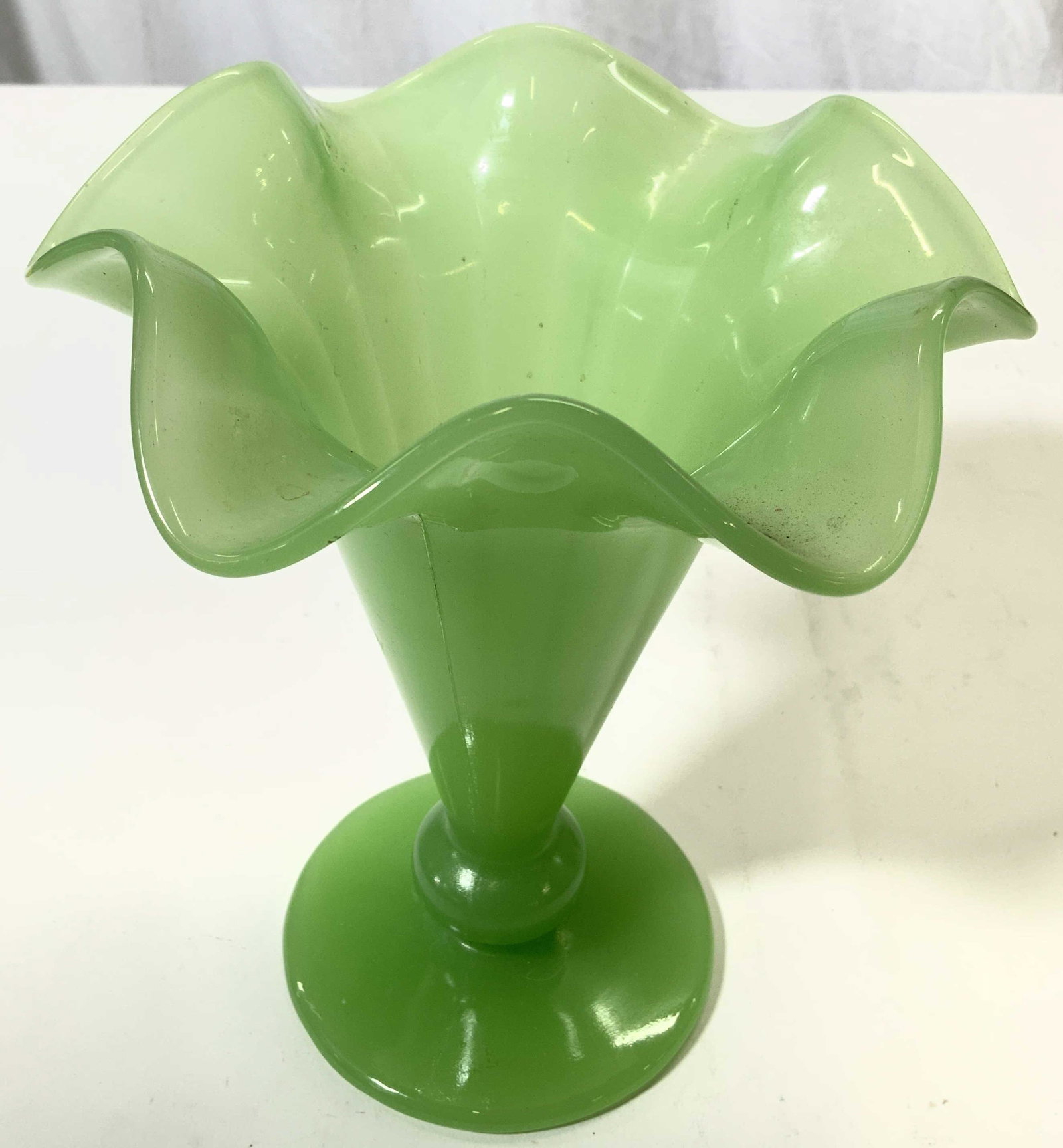 Footed Handkerchief Glass Vase Vessel: Vessel is green toned and glass. Piece has handkerchief style frilled rim. Base is circular shaped. Piece measures approx 7.5 inches tall 6.5 inches wide. Vase, vessel, handkerchief glass, footed glas
