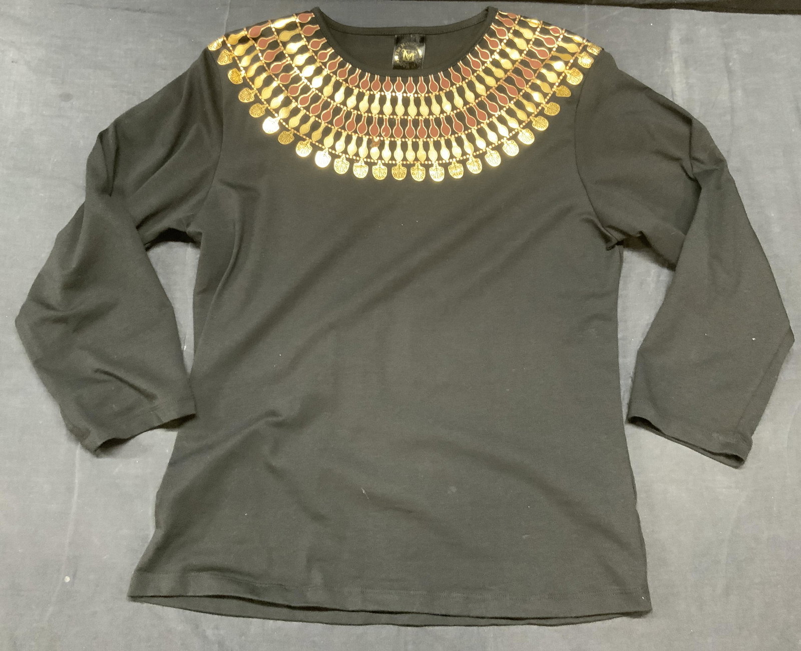 MET MUSEUM OF ART Art Deco Long Sleeve Shirt: METROPOLITAN MUSEUM OF ART Art Deco Black Long Sleeve Shirt, ladies size S, cotton spandex blend, with brown and gold colored Art Deco design around collar and shoulders, surface blemish on front. MET