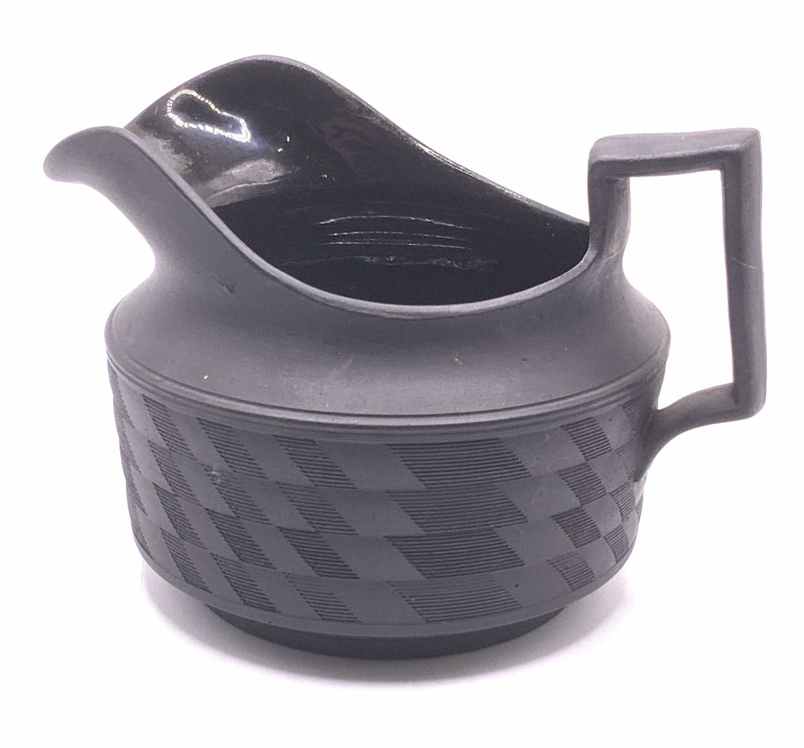 Vintage Black Basalt Textural Creamer: A vintage matte black basalt Jasperware creamer with textural detail on body. Glossy glaze to interior. Measures approx. 3.5 inches diameter and 3 inches tall. Surface wear consistent with age, use, a