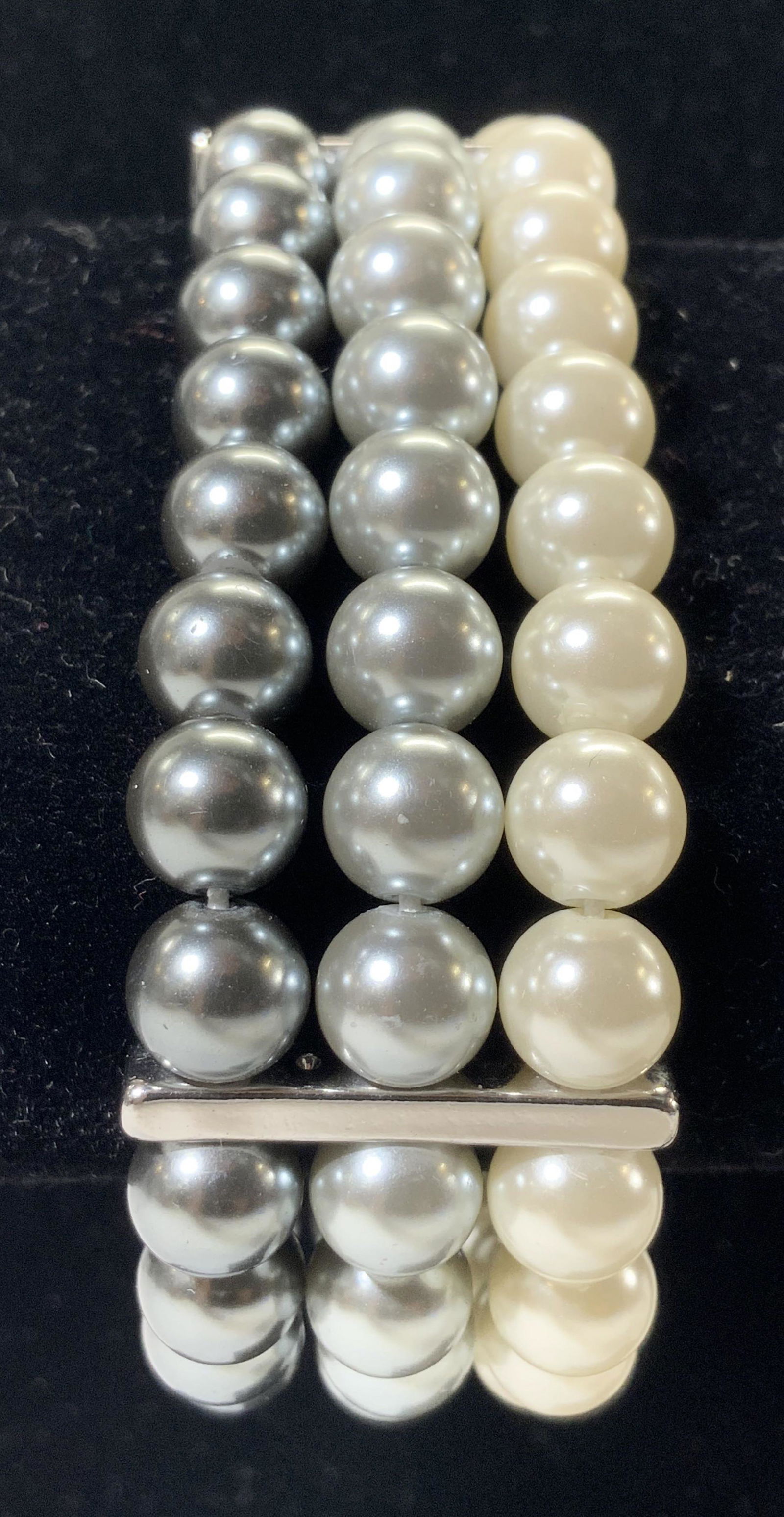 Faux Pearl Multi Tone Stretch Bracelet: Bracelet has stretch band with white, light silver toned & dark silver toned faux pearls. Bracelet has 3 metal bar areas. Bracelet measures approx 4 inches doubles 1 inch wide. Bracelet, stretch brace