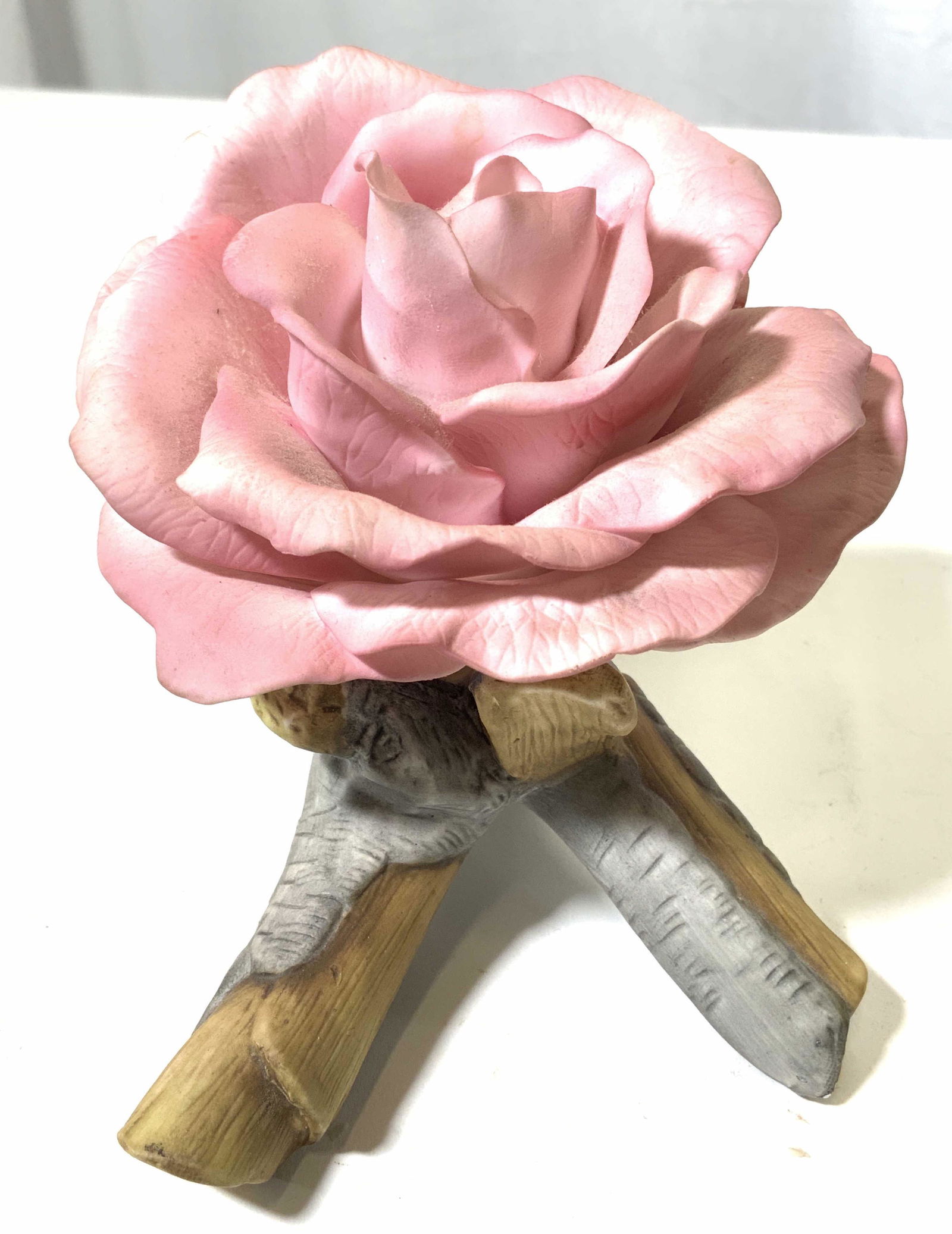 THE QUEEN ELIZABETH ROSE Porcelain Flower: Underside of piece is marked THE QUEEN ELIZABETH ROSE SCULPTED BY RONALD VAN RUYCKEVELT. Piece is porcelain. Depicts a pink flower laying on a branch. Piece measures approx 8 inches long 4.25 inches w