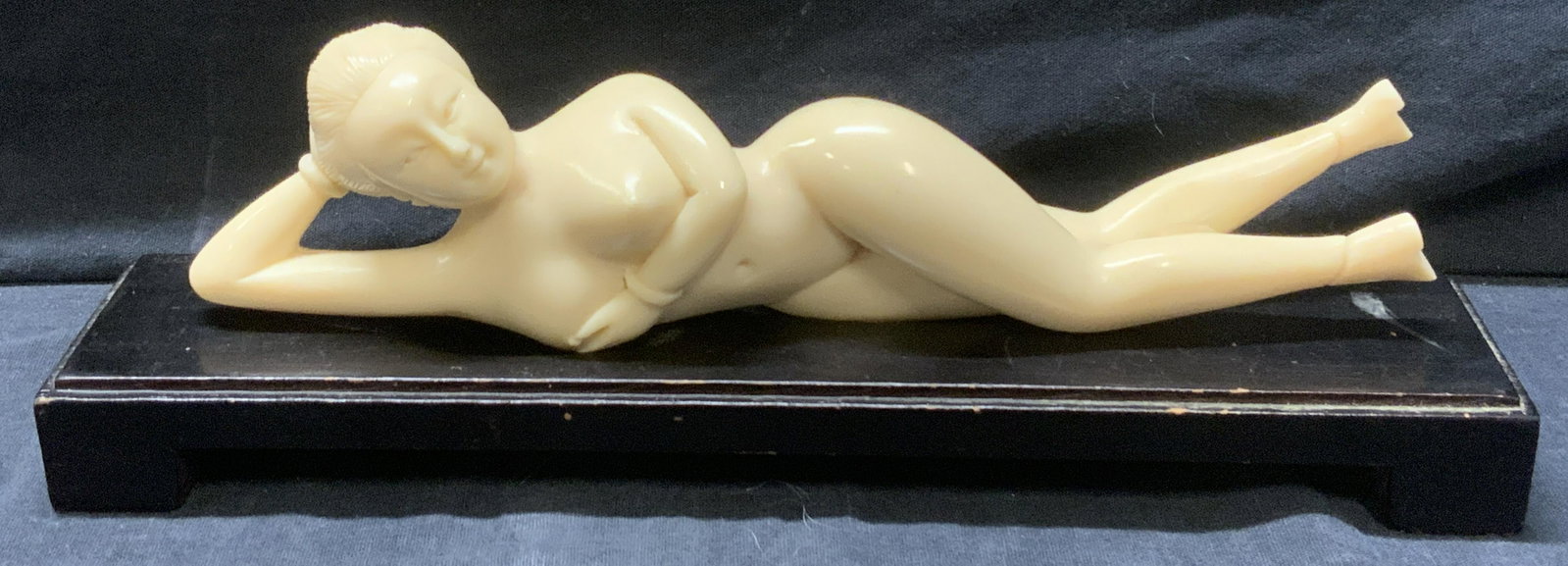 Asian Reclined Female Nude Figural Sculpture: Asian Reclined Female Nude Figural Tabletop Sculpture, resin on black toned wood pedestal, measures approx 3 1/2 x 10 1/2 in. Asian reclined female nude Figural sculpture, tabletop sculpture, resin fi