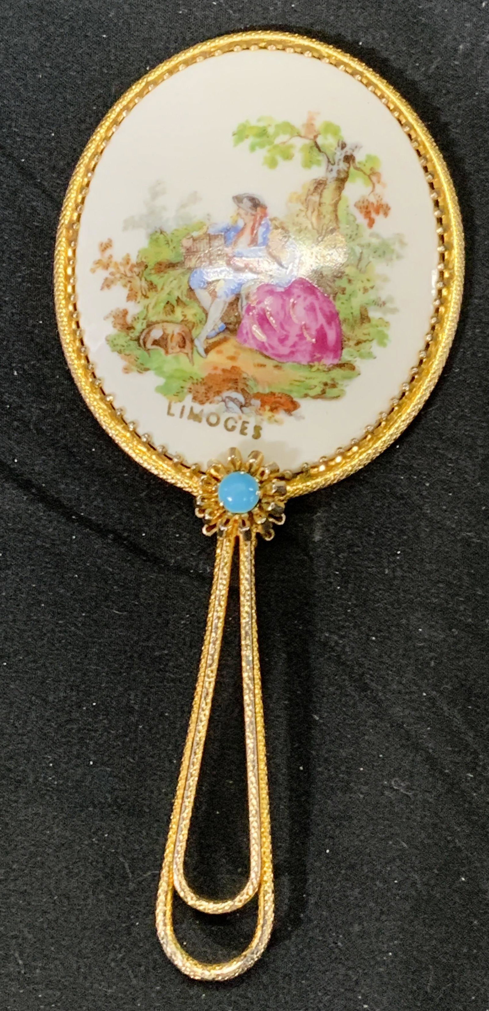 LIMOGES Porcelain Hand Mirror FRANCE: Signed LIMOGES porcelain hand mirror with gold tone handle and painted figural motif to back of mirror. Vintage condition consistent with age, use, and exposure. Measures approx. 5.25 inches long and 