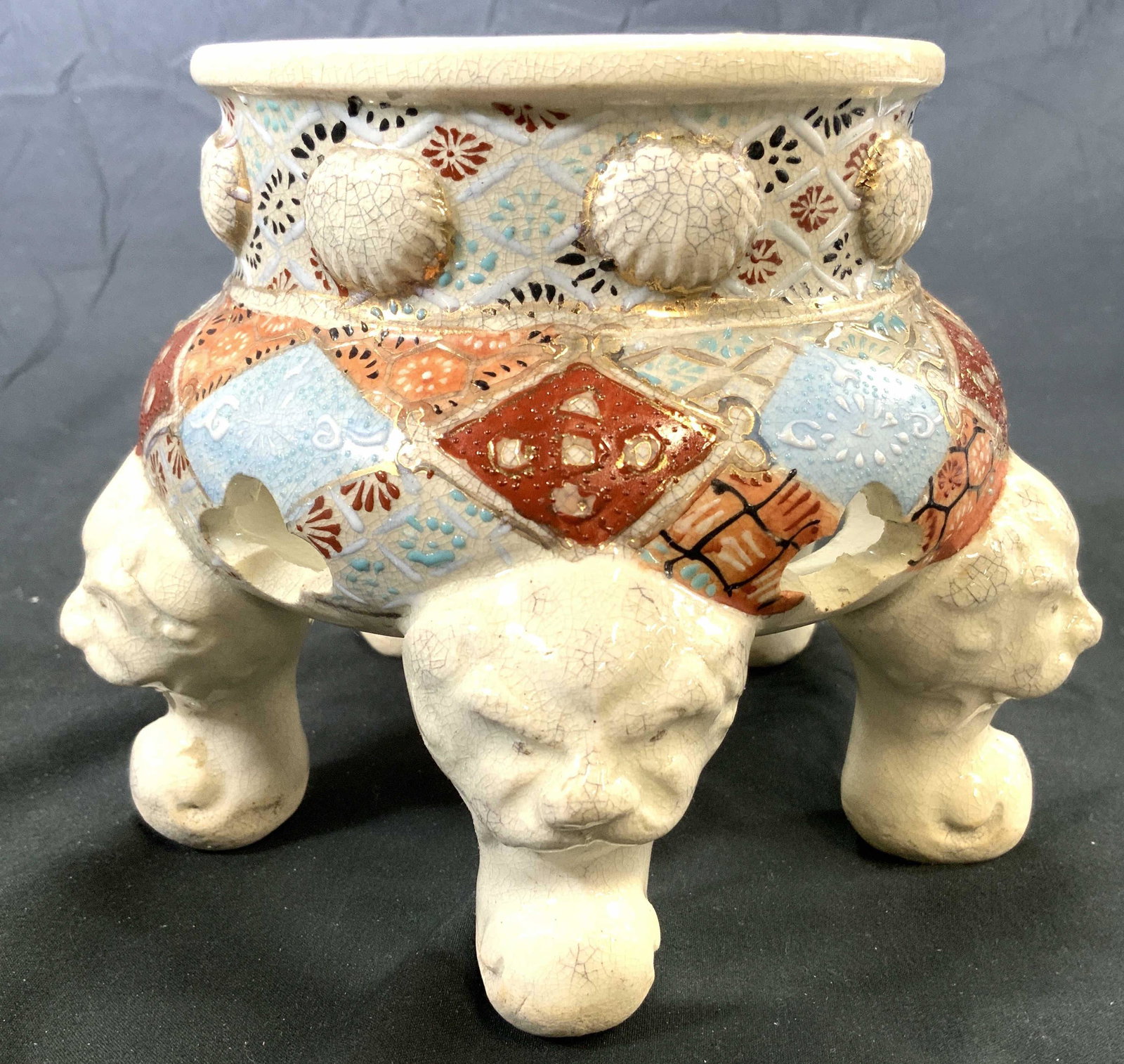 Hand Painted Asian Porcelain Footed Pedestal: Pedestal is hand painted and appears to be porcelain. Piece has 5 feet with foo dog head detail. Piece has intricate multi toned detail. Pedestal measures approx 5 inches tall 6.5 inches wide. Pedesta