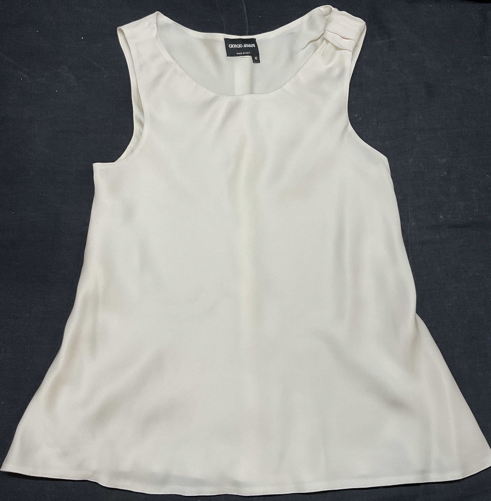 GIORGIO ARMANI White Silk Sleeveless Top: GIORGIO ARMANI Silk Sleeveless Top. European size reads 40. Could possibly be silk, soft hand touch. No Material tag to piece. Detailed shoulder, ruffled detail bottom. No visible wear to piece. Fall 