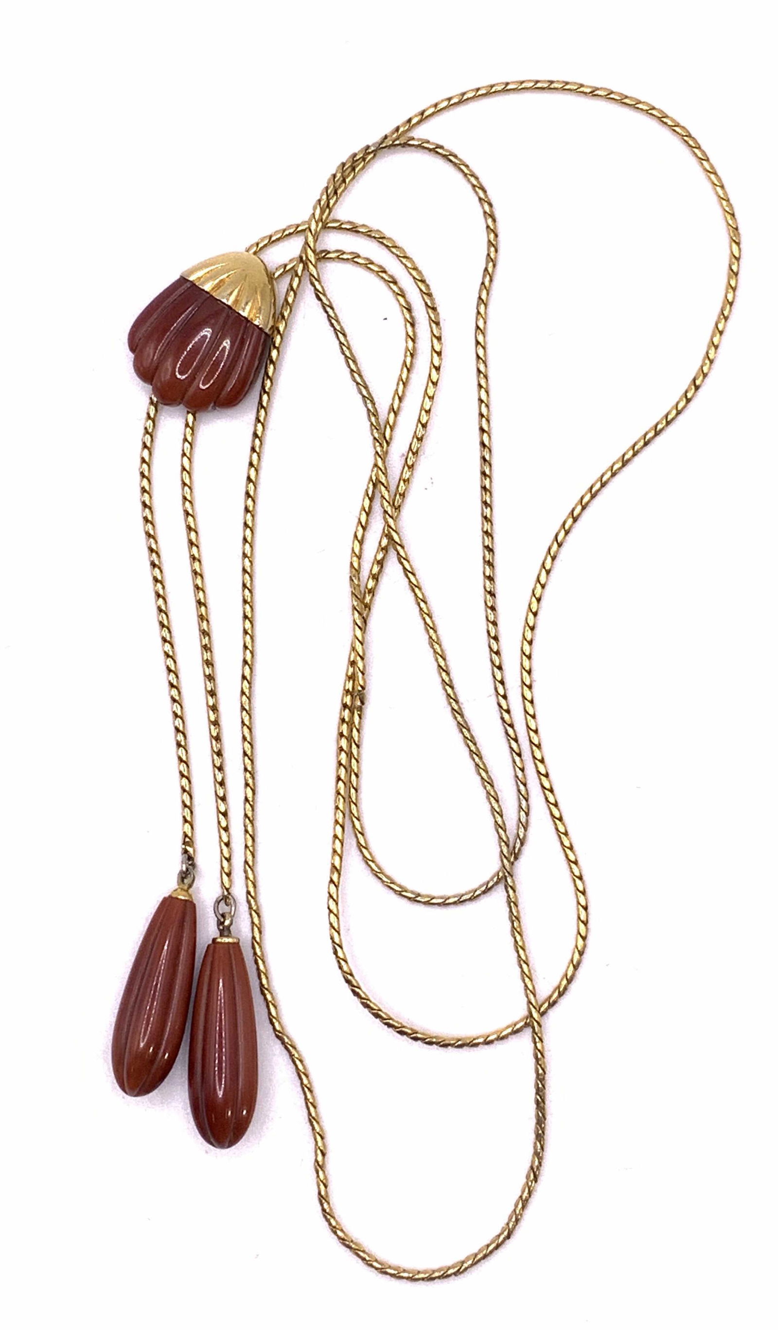 TRIFARI Vintage Gold Tone Lariat Necklace: A vintage Trifari gold tone lariat necklace with rust hued beaded pendants. Signed Trifari to back of pendant. Measures approx. 38 inches long. Property of Palm Beach, Fl Estate. Trifari, vintage trif