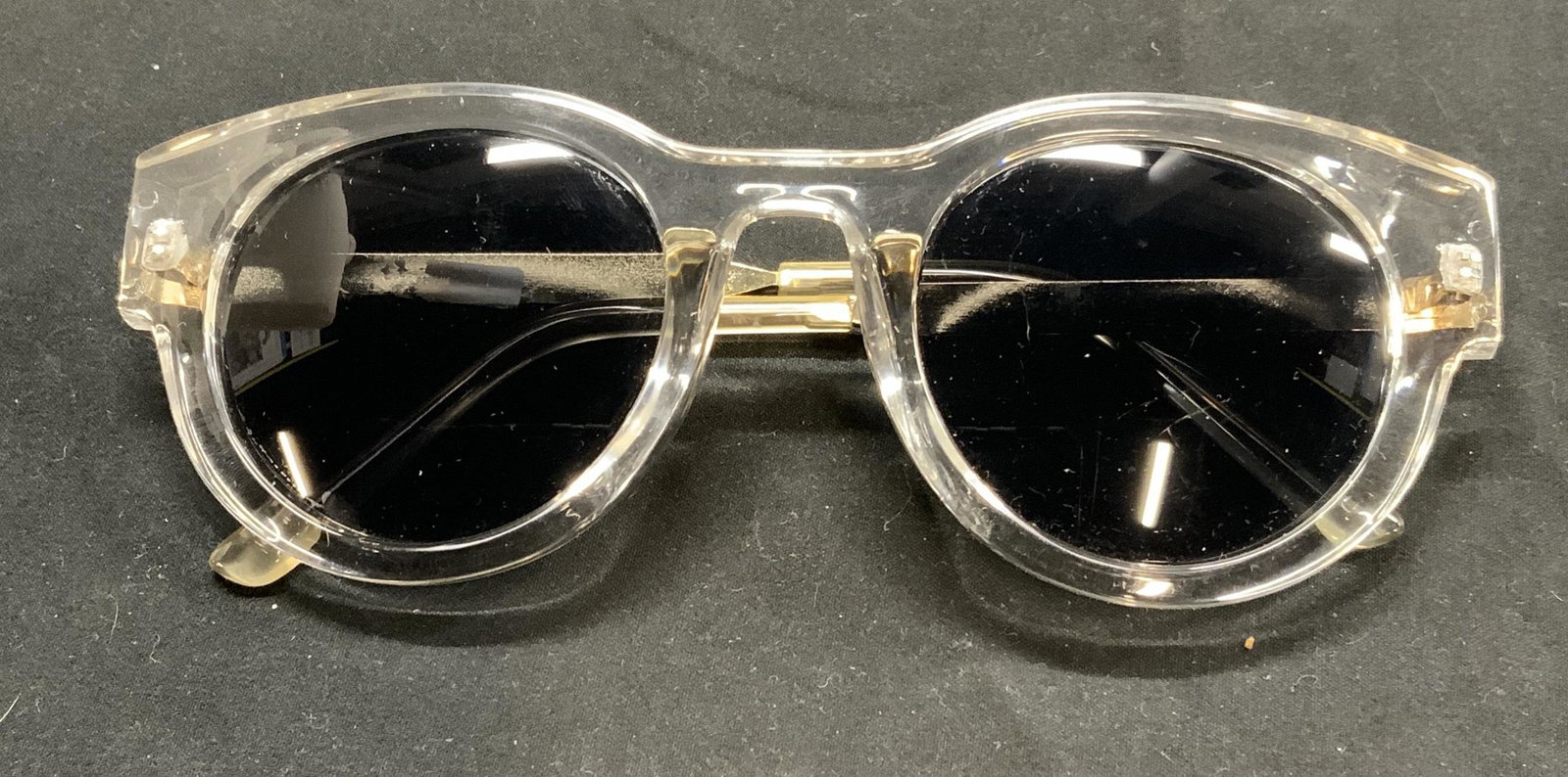 Round Frame Transparent & Gold Tone Sunglasses: Ladies round frame fashion sunglasses with transparent frame and gold tone arms. In good condition. Measure approx. 5.5 x 5.75 x 2 inches. Ladies sunglasses, ladies eyewear, ladies clear frame sunglas