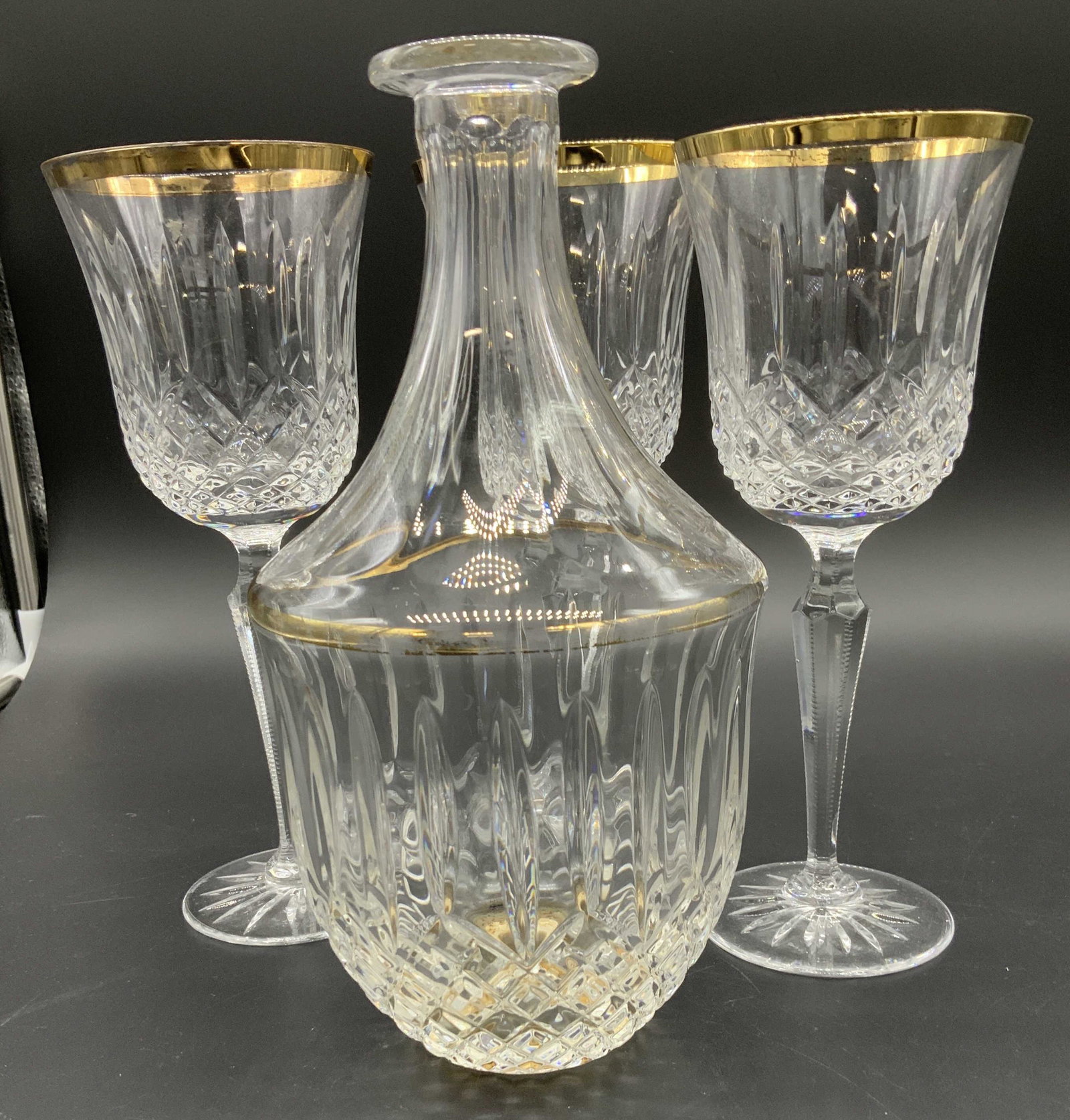 WEDGWOOD Sgn Crystal Decanter and Stemware, 4: Wedgwood Cut Crystal wine glasses, one has chip to lower rim. Each measure 9 x 3.5 in. Reverse bell shape with gilt rim and cut crystal stem, base and goblet. Matching decanter, has not stopper, measu