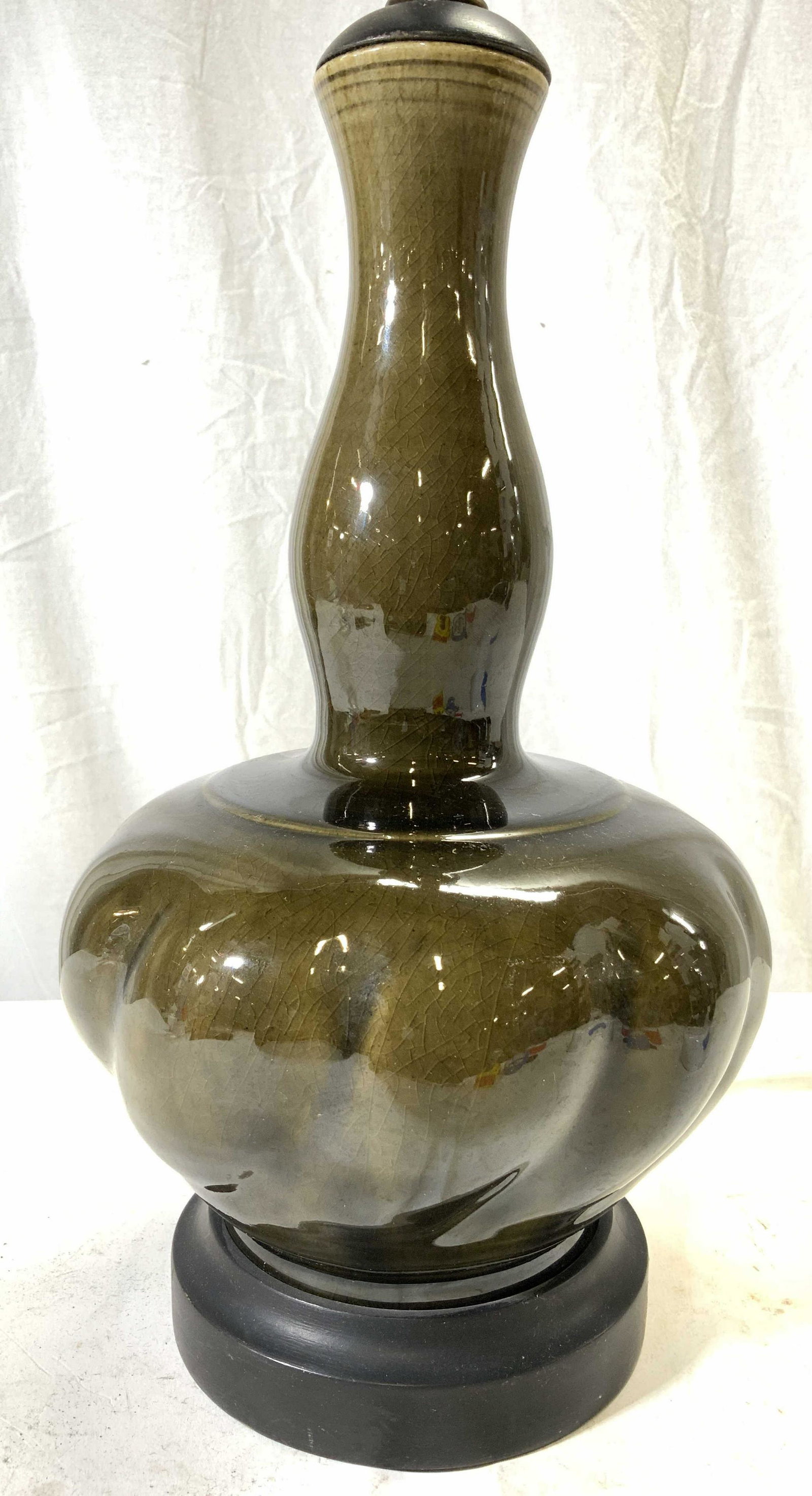 Vintage Olive Green Porcelain Lamp: Lamp is vintage and appears to be porcelain possibly ceramic. Piece is olive toned with slight variations in gradients. Base is black toned & circular shaped. Lamp measures approx 26 inches tall 7.5 i