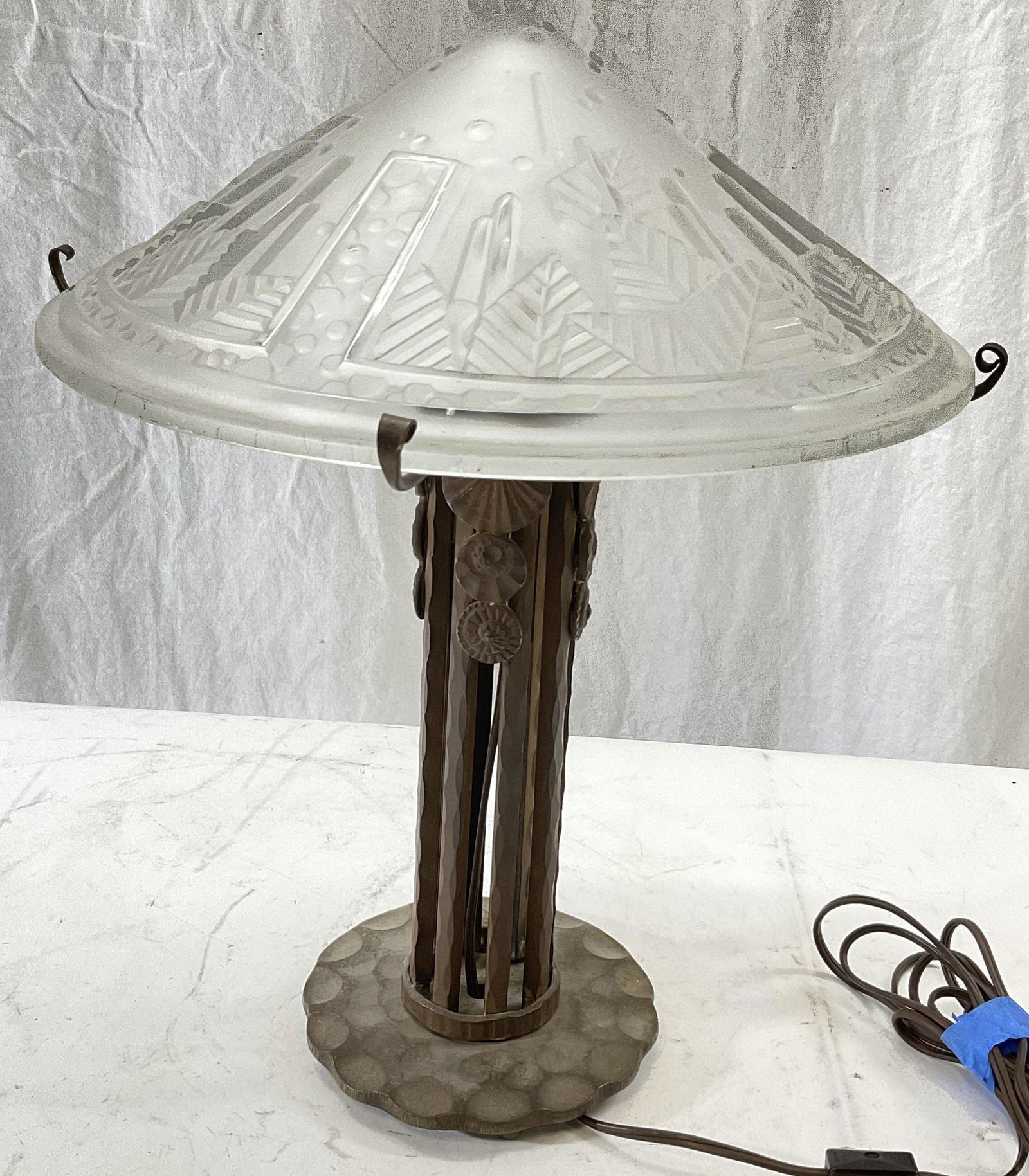 Small Iron Signed Frosted Shade Table Lamp: Frosted Shade signed with Muller Freres LUNEVILLE. Minor chips to shade. Not tested for functionality. Measures approx 16H x 12.5 inches. Surface wear to piece consistent with age and use. Significant