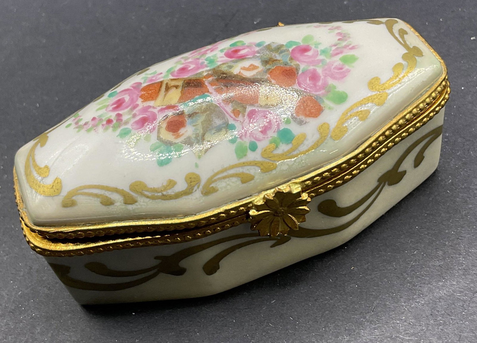 Limoges Porcelain Trinket Box, France: Limoges Porcelain Trinket Box. Bottom reads ‘decor main, Limoges france.’ Measures approx 3 x 1.5 inches. Surface wear to piece consistent with age and use. Trinket box, Limoges box, floral detail