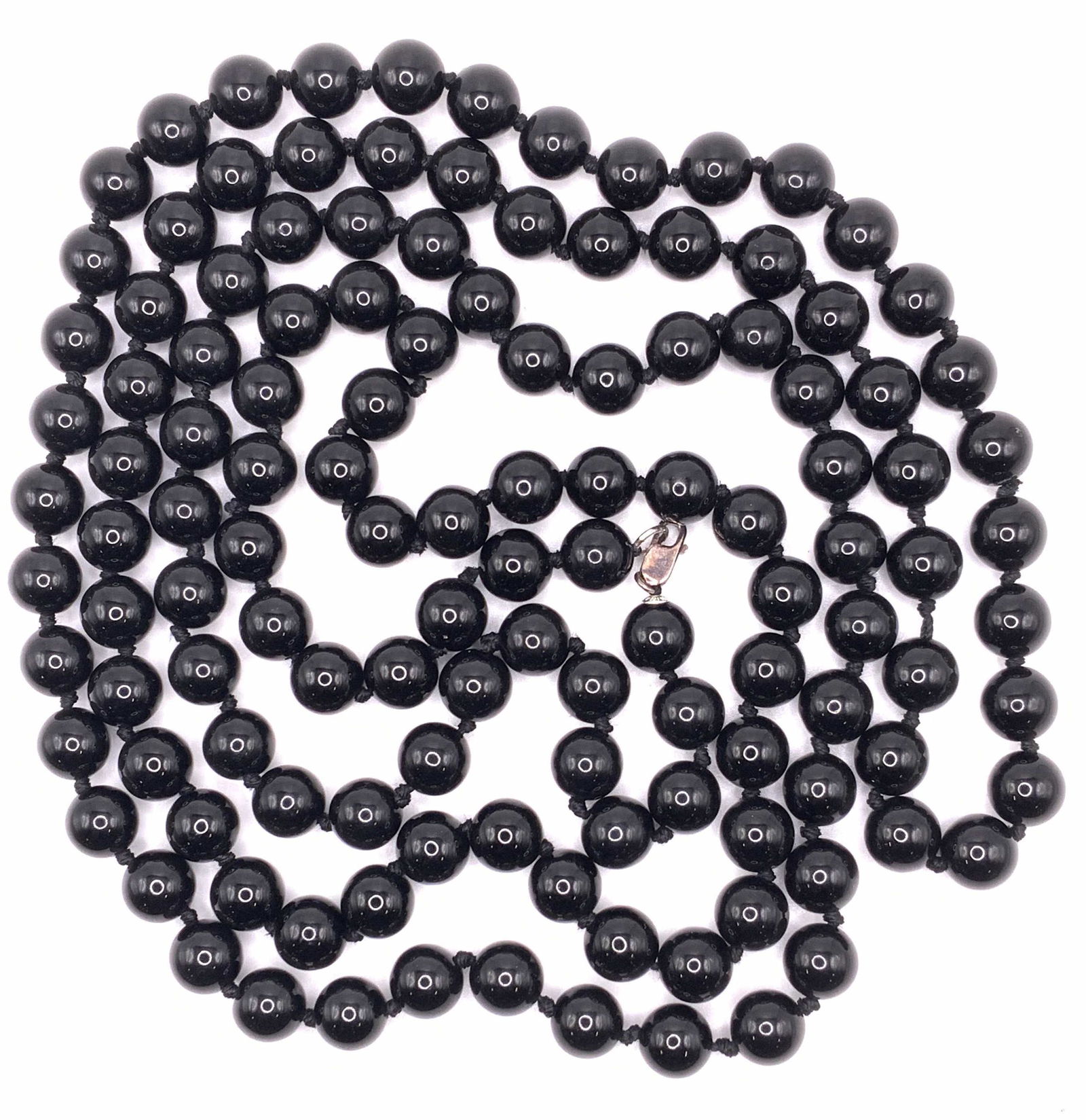 Vintage Black Beaded Rope Necklace: A vintage black beaded necklace, possibly Jasper or onyx, with double knotted cord. Measures approx. 60 inches long. Lobster claw clasp. Piece is weighted approx. 190.7 grams. Property of Palm Beach,