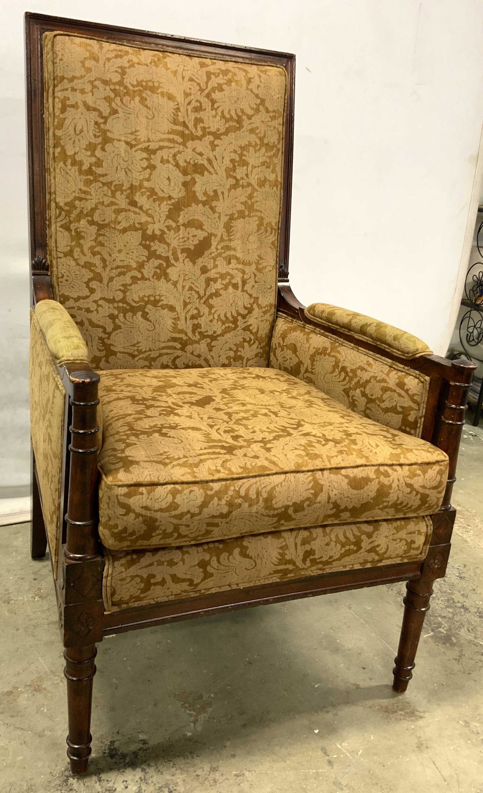 Carved Wood High Back Armchair W Floral Upholstery: Chair has high backrest. Piece has floral detailed upholstery. Some edges of upholstery have double welting. Piece has carved wooden frame with cushioned armrests. Piece measures approx 45 inches tall