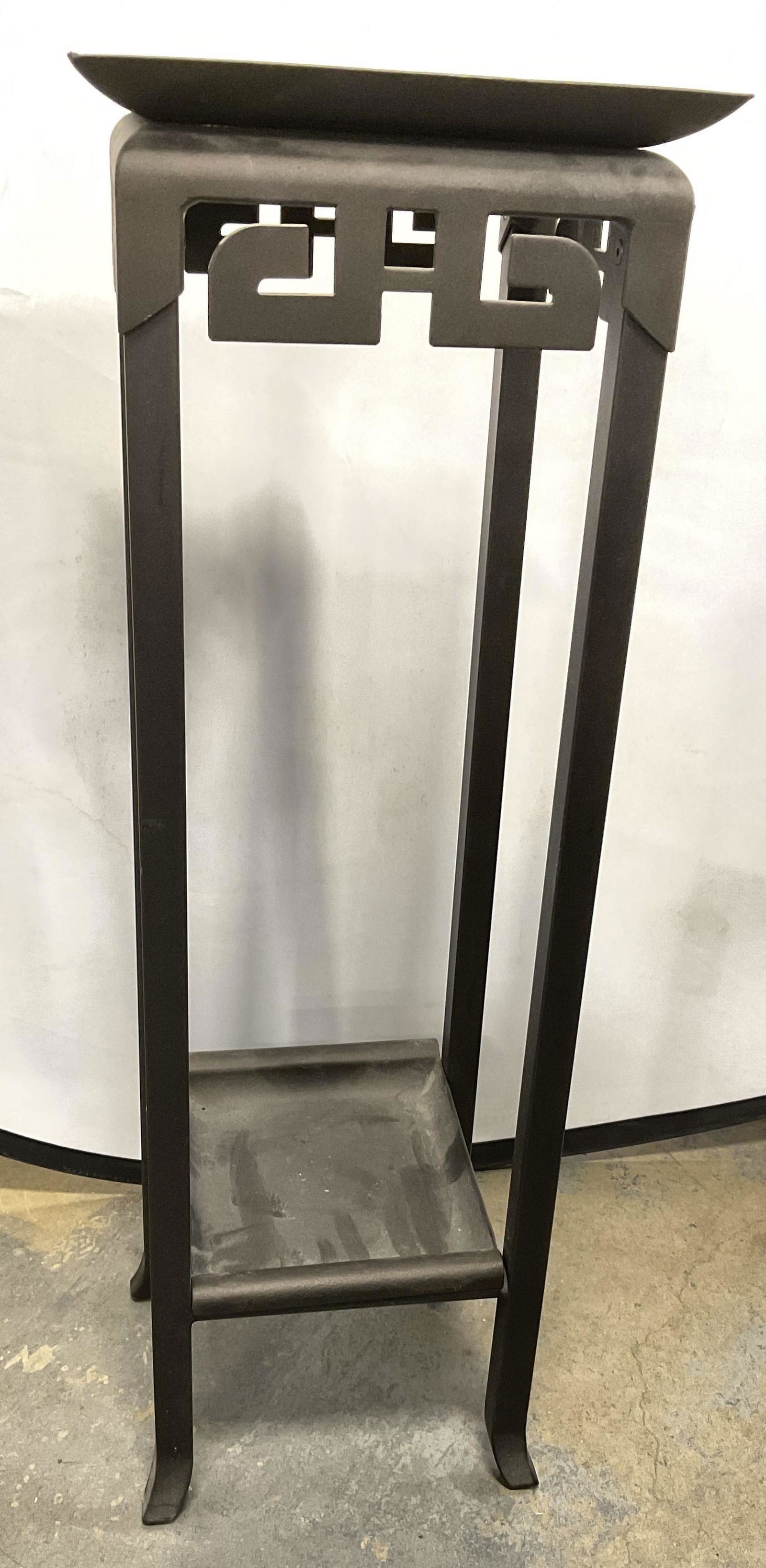 Bombay Company Metal Plant Stand, Greek Key Design: Bombay Metal Pedestal W Removable Bottom. Bottom is able to be removed. Dark metal, with Asian style detail. Measures approx 36H x 12w x 12D inches. Surface wear to piece consistent with age and use.