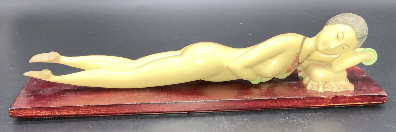 Asian Female Reclining Nude Sculpture , 3 pcs: Signed Composite Female nude and pillow, on stained wood base. Woman is Chinese, completely nude, wearing shoes and jewelry with her hair up. Her arm is resting on a pillow. Lady Measures 11.75 in. Lo