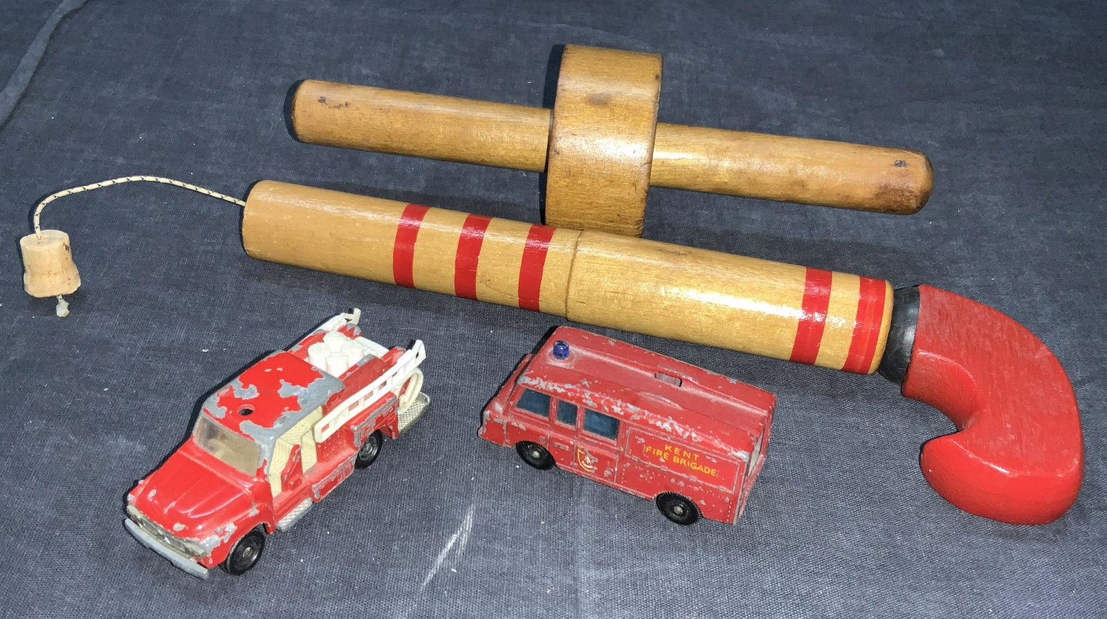 Group Lot 4 Vintage Wooden Toys & Cars: A group lot consisting of 1 vintage wooden cork gun, 1 wooden adjustable tool and 2 vintage toy cars. 1 car resembles a fire trunk marked Tomica, 1975 on underside. The other toy car is a red van with