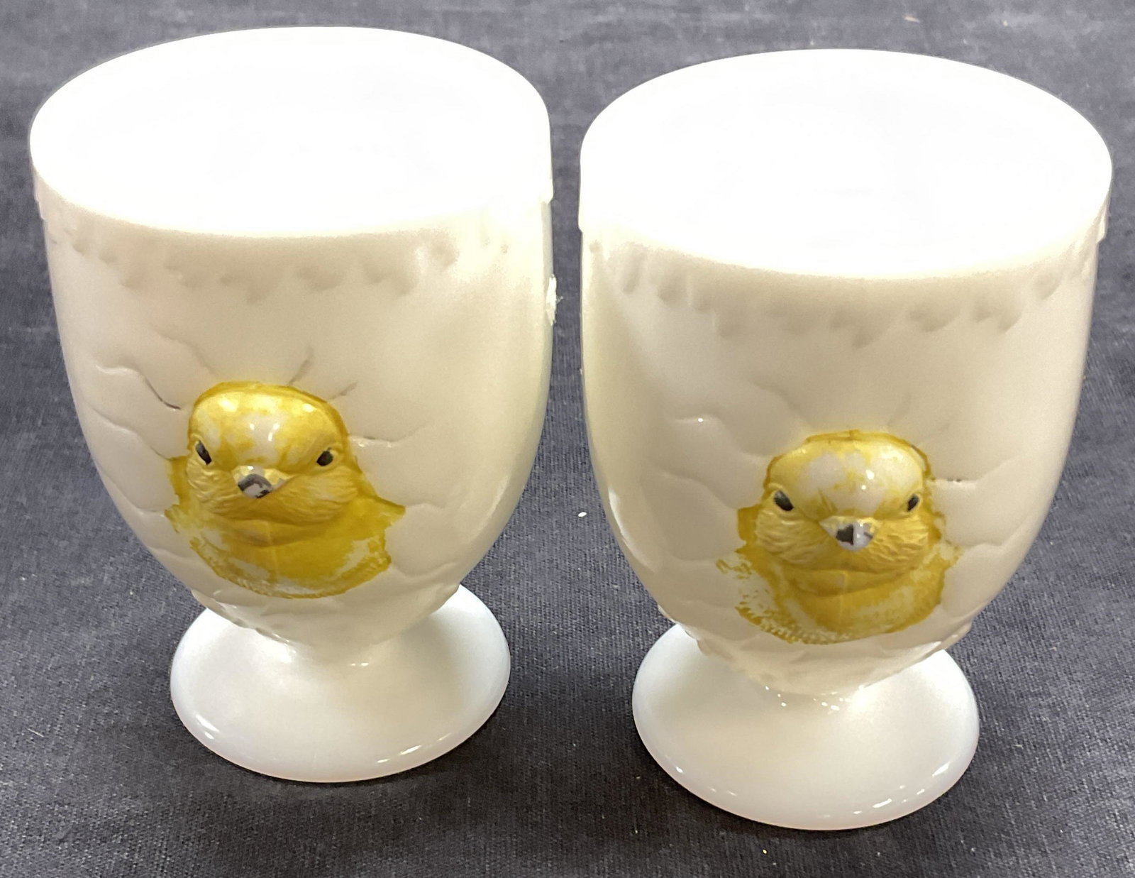 Pair of Egg Servers W Handle: Pair of porcelain egg servers with handles. Chicks appear to be cracking through egg. Measures approx 3 x 3 inches. Surface wear to piece consistent with age and use. Paint wearing to chicks. 11S Egg 