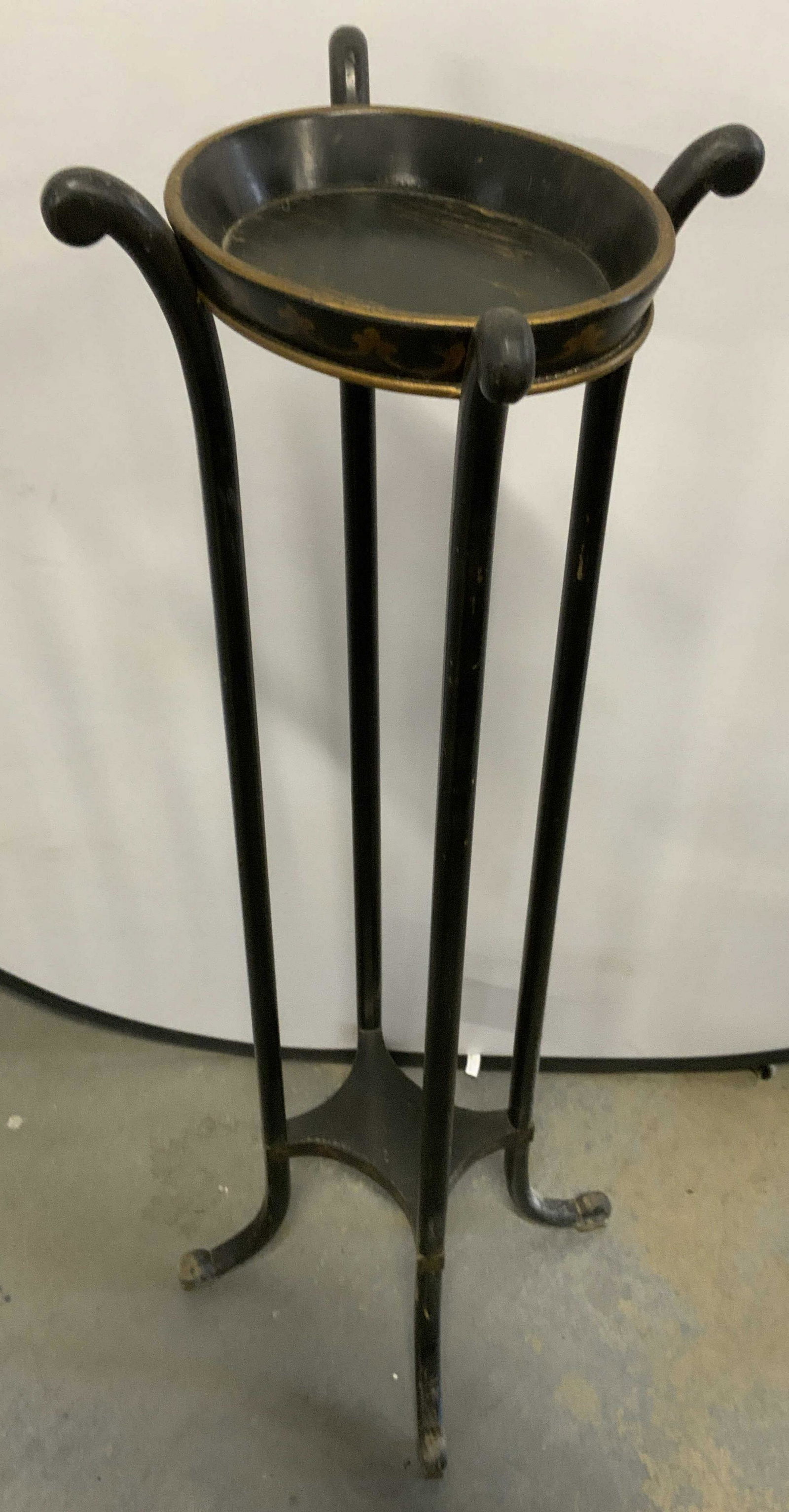 Vintage Hand Painted Black Wooden Pedestal: A vintage wooden pedestal. Black finish. Hand painted gold hued designs to the base and topper. Stretcher to the center. Four legs. Curled feet. Measures approx 49H x 15W (measured foot to foot) inche