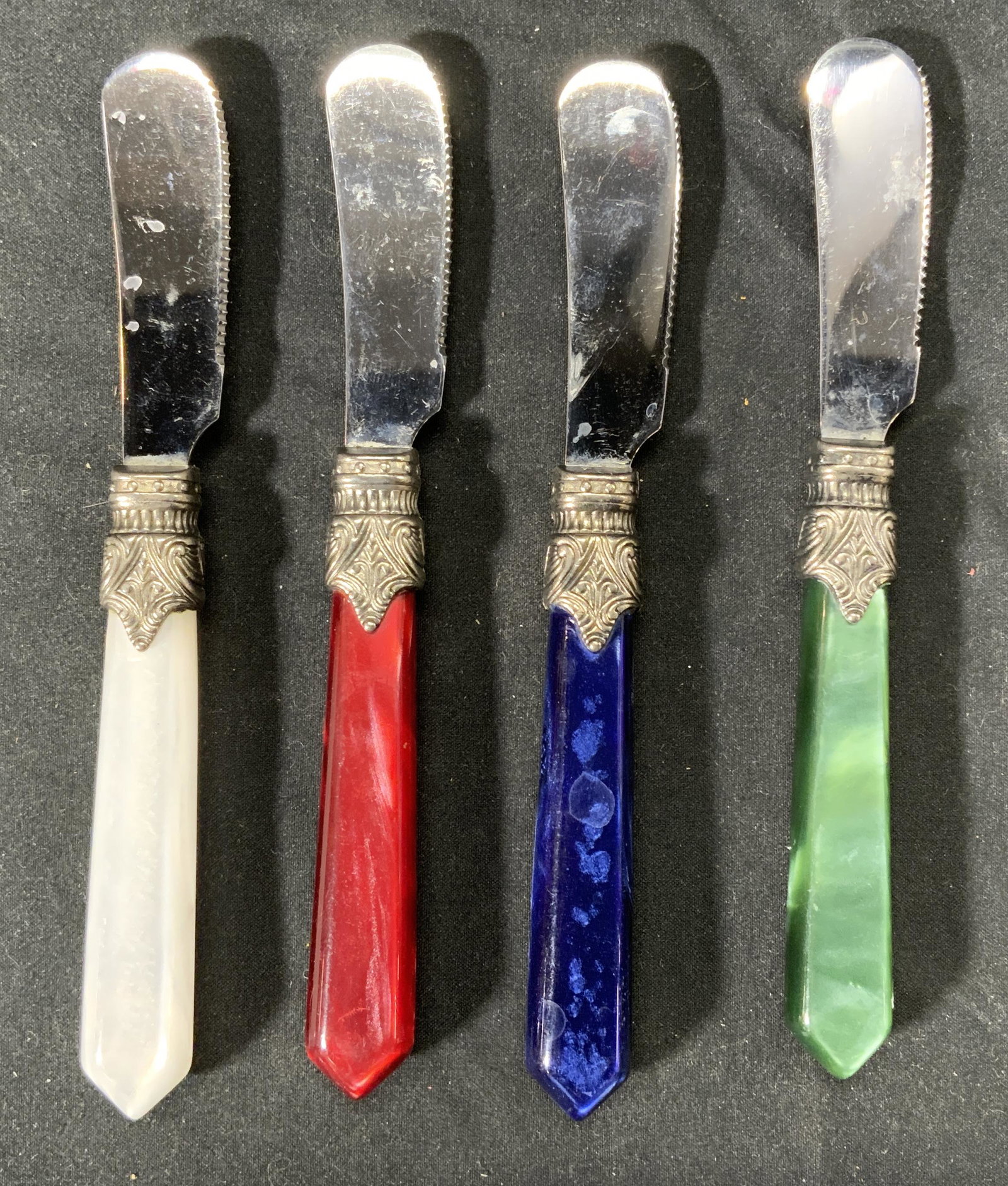 Set 4 INOX Iridescent Handle Butter Knives, ITALY: Set of 4 INOX butter knives with iridescent white, red, blue, and green handles. Measure approx. 5.75 inches long each. Made in Italy. Surface wear consistent with use and exposure. Marked INOX to bla