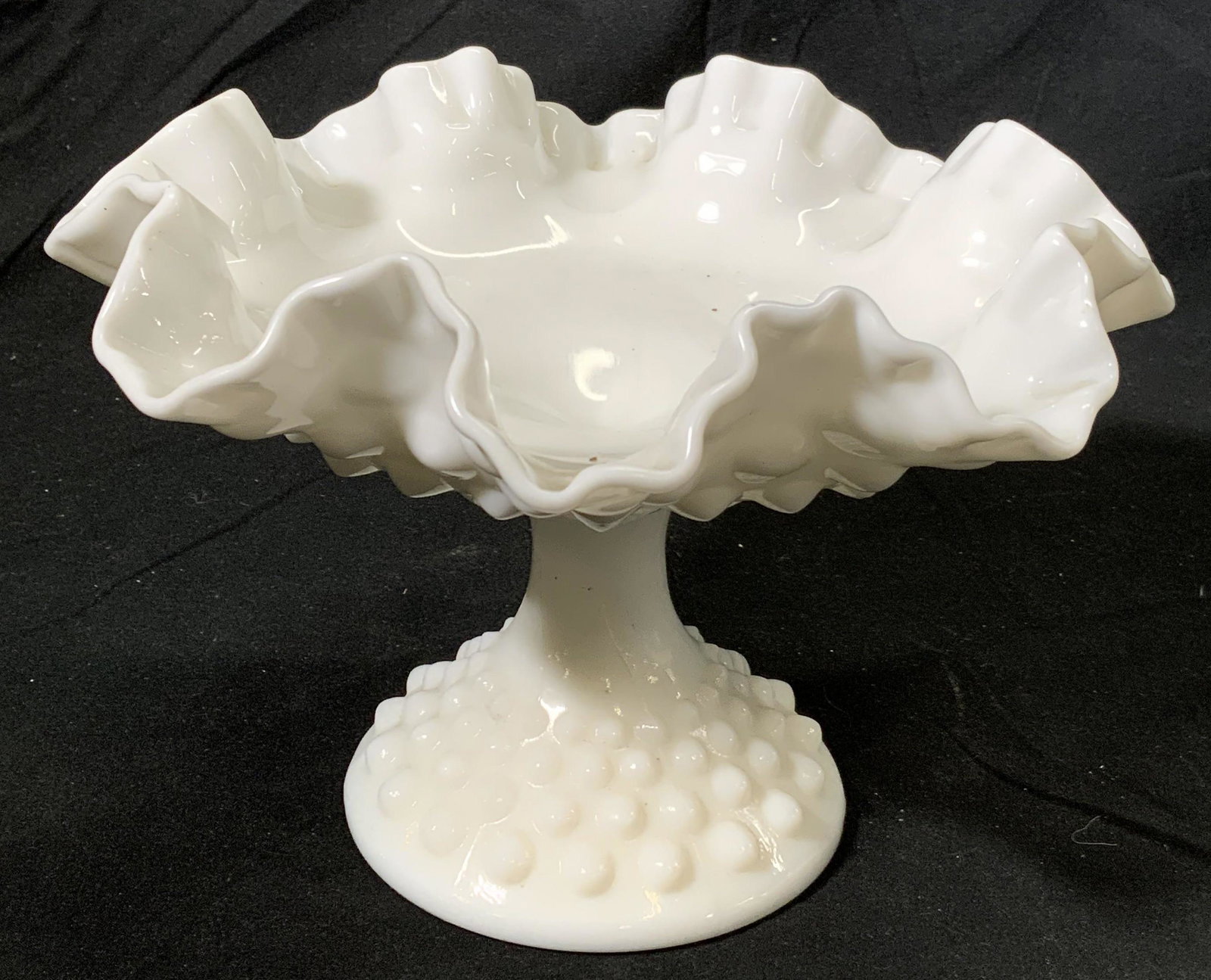 Vintage Hobnail Milk Glass Footed Compote Dish: A vintage milk glass footed compote dish with hobnail detail and handkerchief glass rim. Measures approx. 8.25 diameter x 5.5 inches tall. Some wear to surface consistent with age and exposure, Compot
