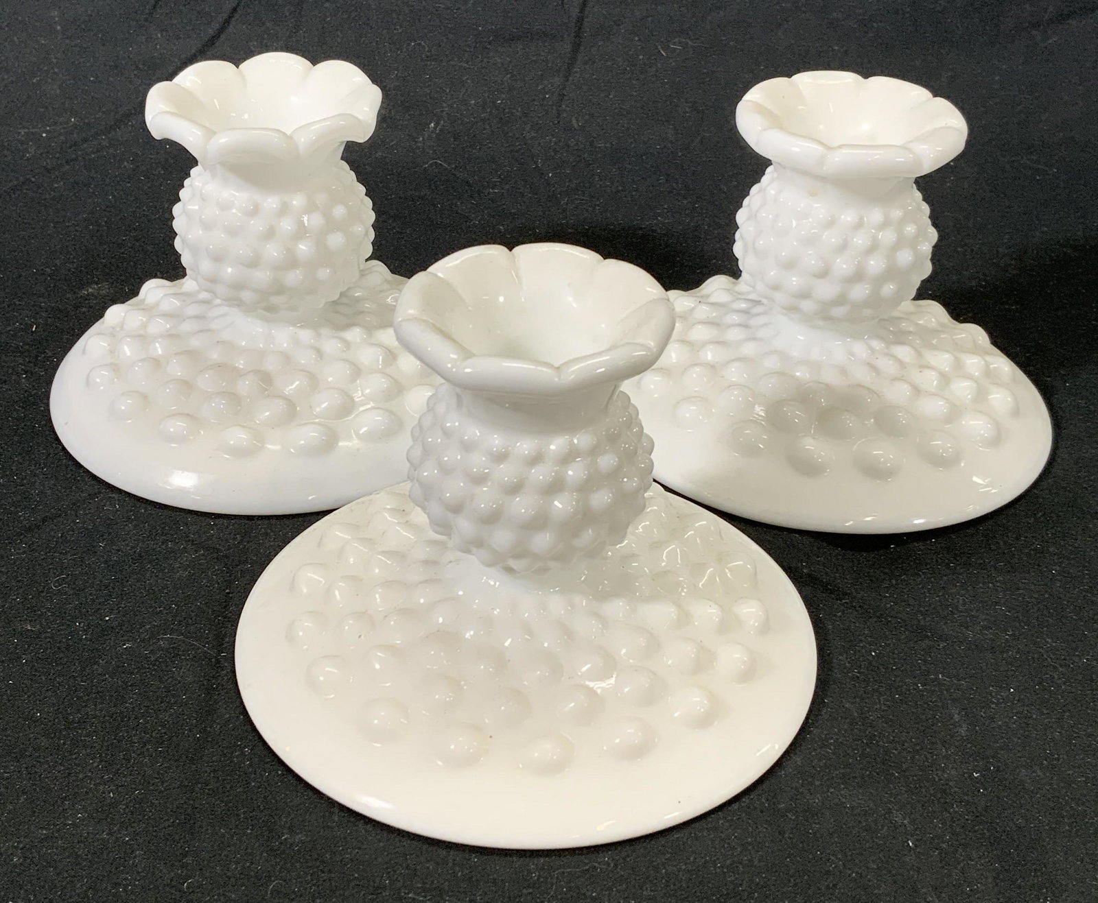 Set 3 Milk Glass Hobnail Candle Holders: Set of 3 vintage milk glass candlesticks with hobnail detail. Measure approx. 4.5 inches diameter and 3 inches tall. Some wear to surface consistent with age and exposure. Milk glass, milk glass candl