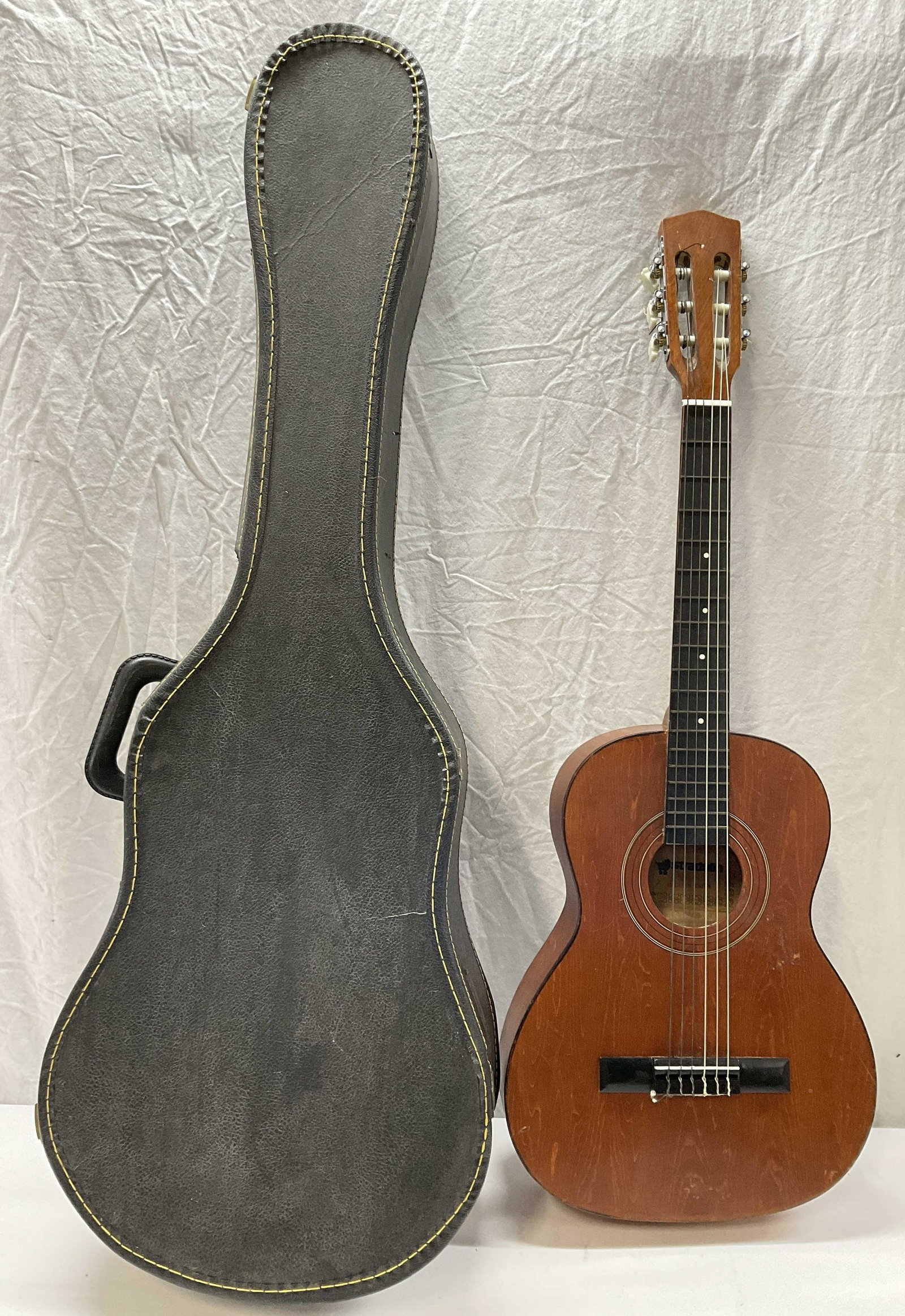 STRADOLIN Metal/Nylon String Kid Guitar & Case: STRADOLIN Metal/ nylon String kid Sized Guitar & case. Label reads STRADOLIN. Damage to piece. Missing tightening screw for tuning string. Needs tuning and re stringing and some maintenance. Measures 