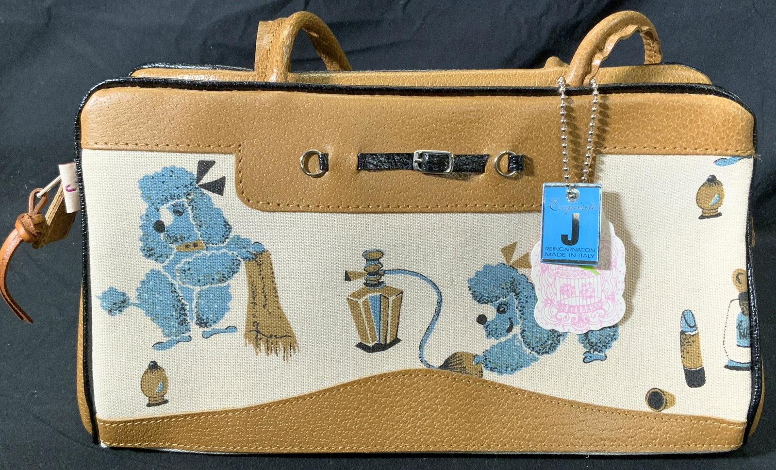 Vintage EXQUISITE J Handbag w Poodle Motif NWT: Vintage Exquisite J handbag with poodle and perfume bottle motif in hues of cream, brown, and blue. Top zipper closure with one slot pocket to interior. Designer label to interior patch. Includes pock
