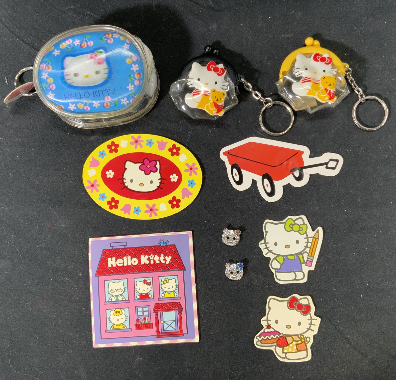 Lot 10 HELLO KITTY Vintage Keychains & Magnets: Lot of 10 vintage Hello Kitty keys chains and magnets. 1 zippered pouch with holographic detail keychain, measures approx. 3 x 2.5 inches. 2 kiss clasp pouch keychains in black and yellow, measure app