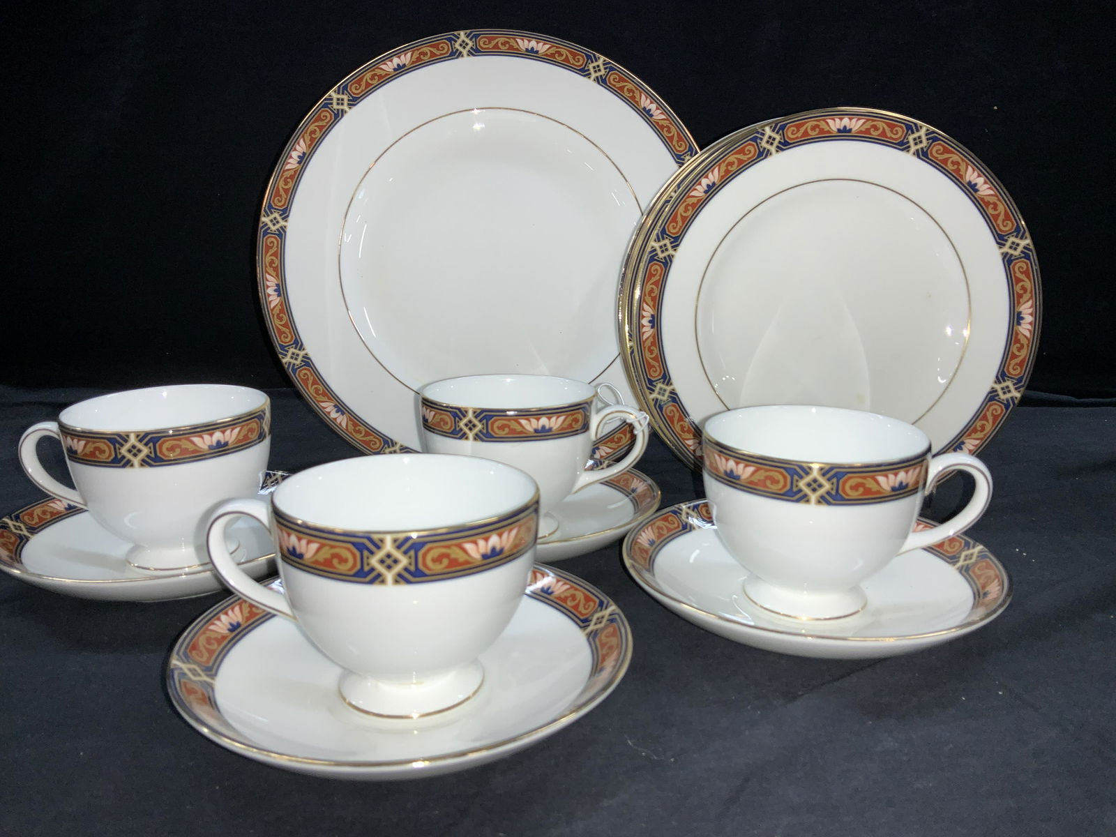 WEDGWOOD Chippendale Fine Bone Chinaware 16: Wire bone China with Lotus flower border in gilt, blue and orange. Signed Wedgwood Chippendale Made in England. 2 dinner plates 10.75 in. 6 luncheon plates. 4 footed tea cups and 4 matching saucers. c