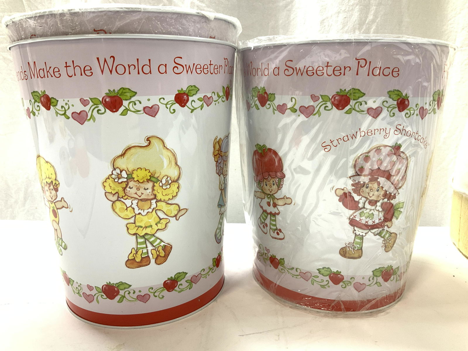 Set 3 Strawberry Shortcake Metal Receptacles, New: 3 Strawberry Shortcake Metal canisters, 2 new in package, 1 new out of package. Displays Strawberry shortcake and her friends, a popular cartoon and doll series in the 1980s. Can reads ‘Friend Make