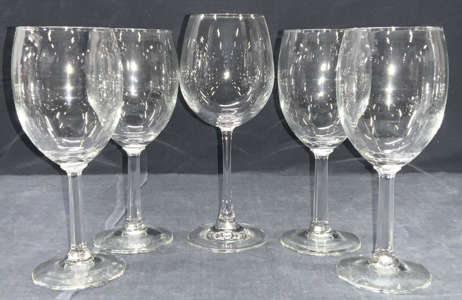 Lot 5 Glass & Crystal Stemware: 5 stemware glasses. 4 with geometric stems made of glass, approximately 7 inches tall and 1 crystal stemware glass marked Di Vino on base, approximately 8 inches tall. Glassware, crystal stemware, Cle