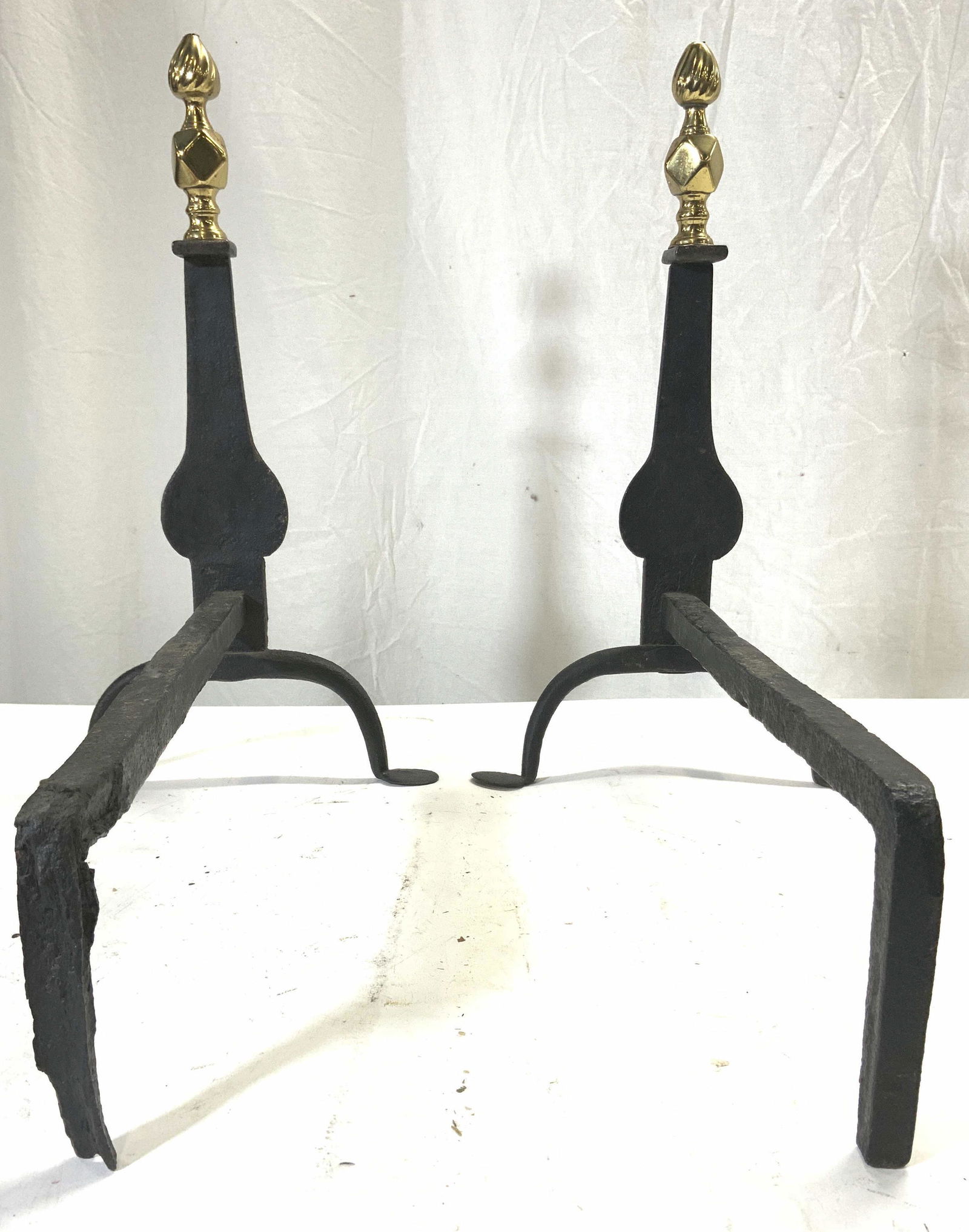 Pair Vintage Black & Gold Andirons: Andirons are vintage. Each piece appears to be brass and iron, with black bases and gold toned finials. Andirons measure approx 17 inches long 17.5 inches tall 10 inches wide. Andirons, vintage andiro