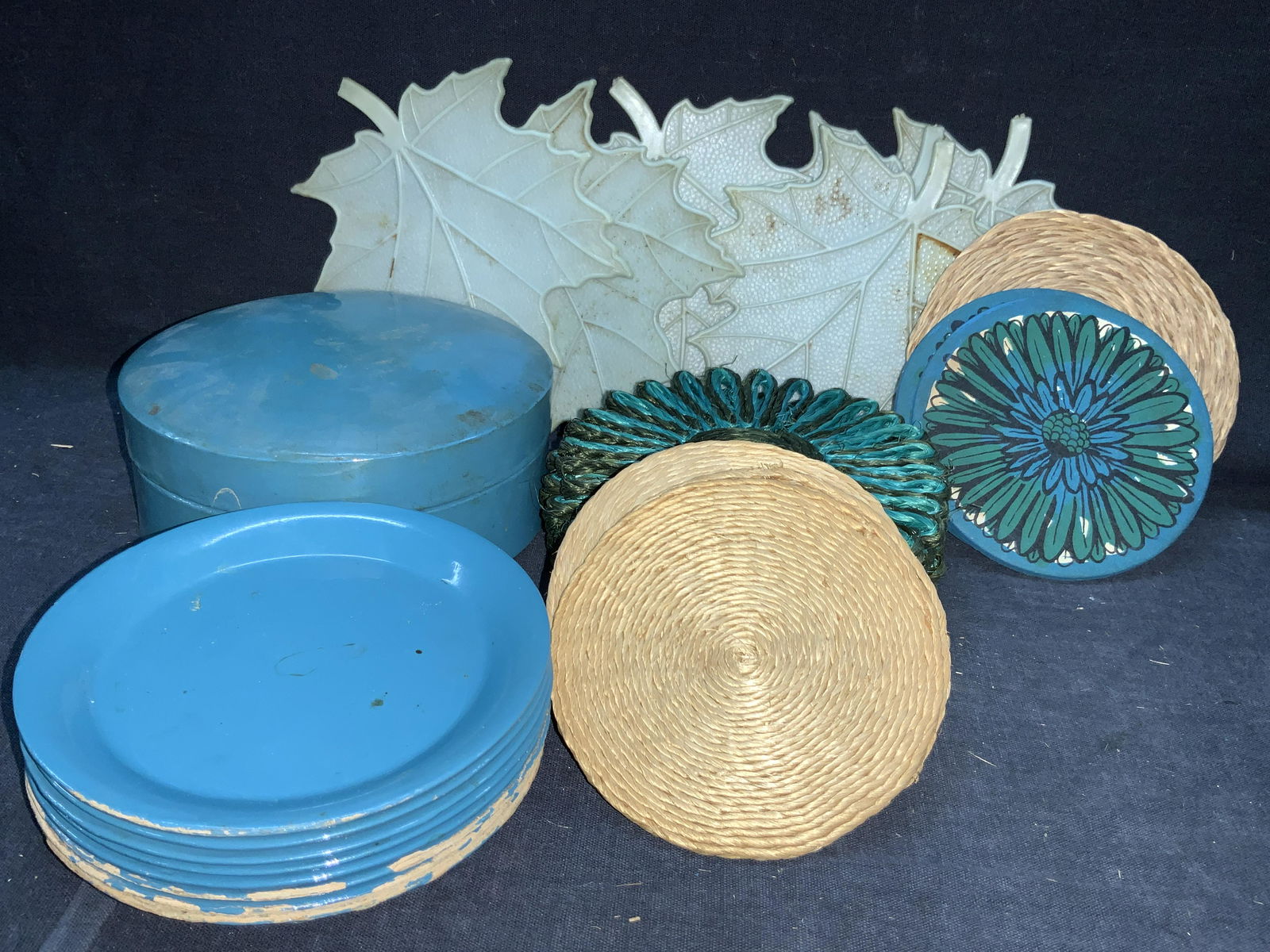 Group Lot Vintage & Woven Rattan Coasters: 6 sets of vintage and woven rattan coasters. 1 set of painted blue toned wooden coasters in blue toned case. Approximately 5 inch diameter. Marked Creative Imports Inc. NY. Japan. 5 blue and green dye