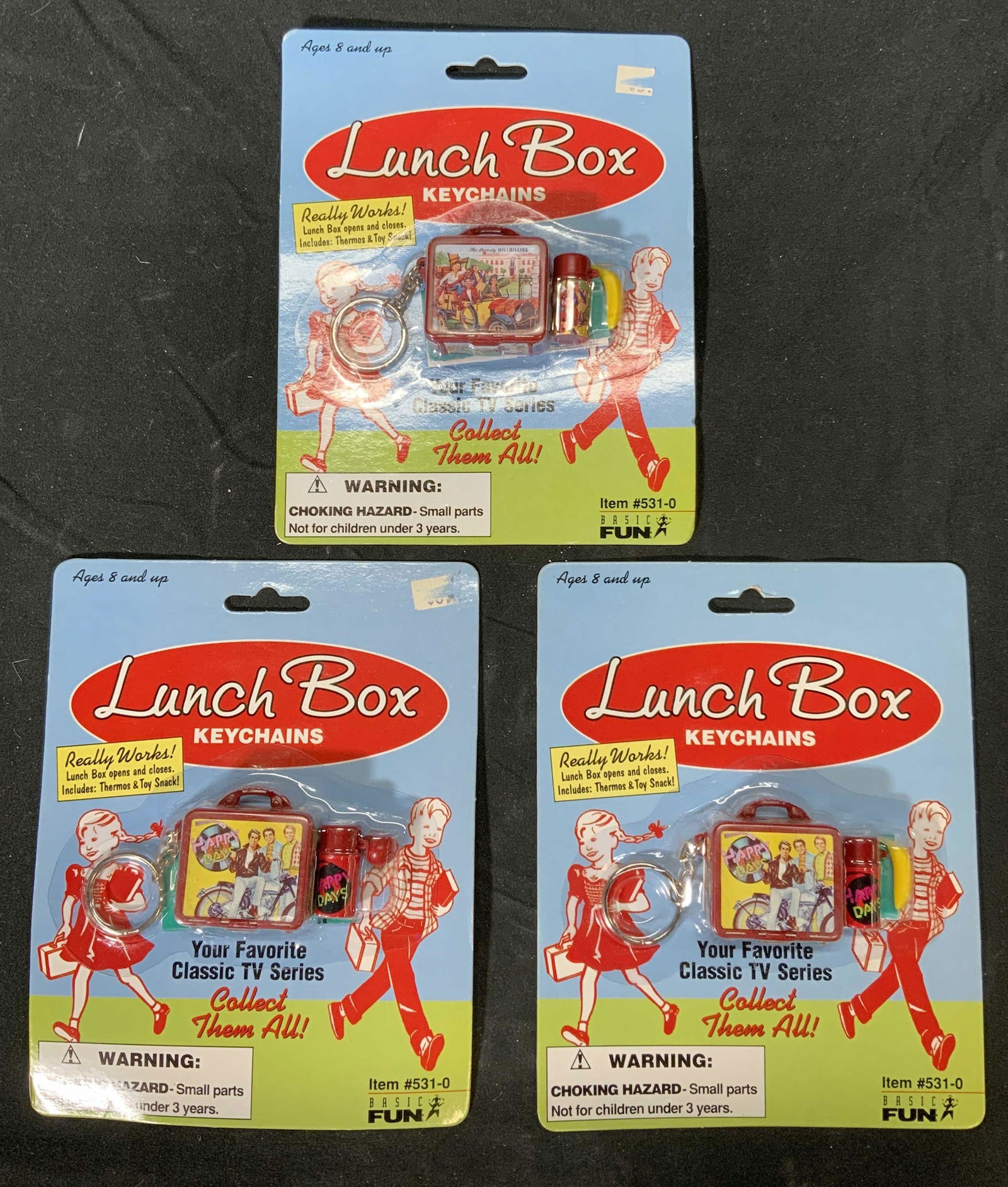 Lot 3 HAPPY DAYS & BEVERLY HILLBILLIES Keychains: 2 vintage Happy Days lunchbox keychains and 1 Beverly Hillbillies lunchbox keychain. All pieces new in original packaging. Packages measure approx. 7 x 5.5 inches. Happy days, Beverly hillbillies, ret