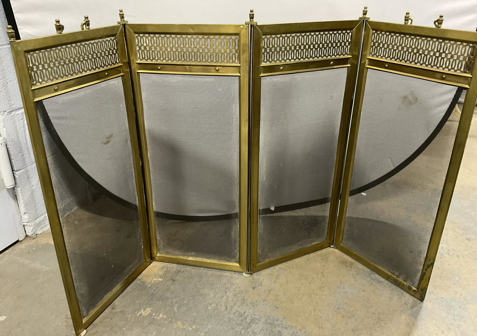 Foldable Brass Fireplace Screen: Foldable Brass Fireplace Screen, possibly vintage. Folds up into 4. Measures approx 50 inches open, and 30 inches high. Surface wear consistent with use and age of piece. Some dent and oxidation to me