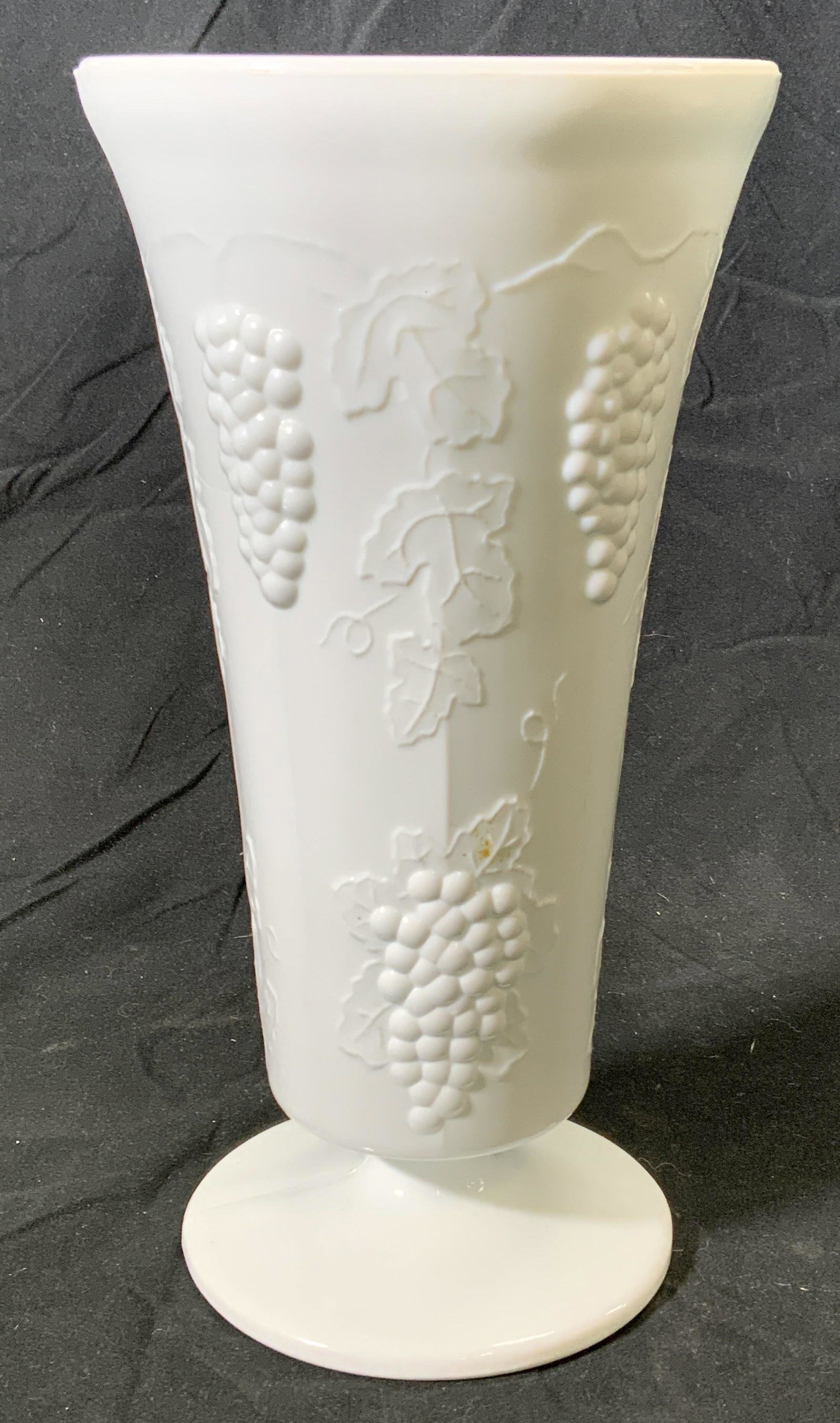 Vintage Milk Glass Grape Vase: A vintage milk glass vase with embossed grape motif. Measures approx. 5 inches diameter and 9.75 inches tall. In good condition, some wear to surface consistent with exposure. Milk glass, vase, milk g