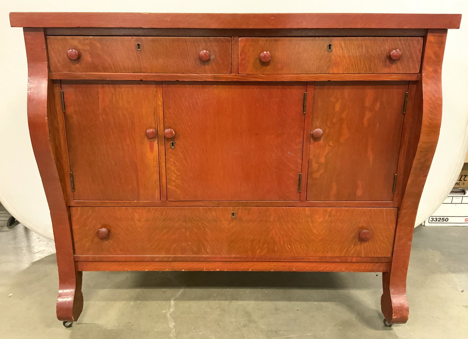 Vntg 1940s American Wooden Sideboard On Casters: Sideboard is vintage possibly antique. Appears to be circa 1940s. Piece has 3 exterior drawers, 3 interior drawers & 3 cabinet doors. Drawers have hand dovetailing. Feet have casters. Sideboard is red