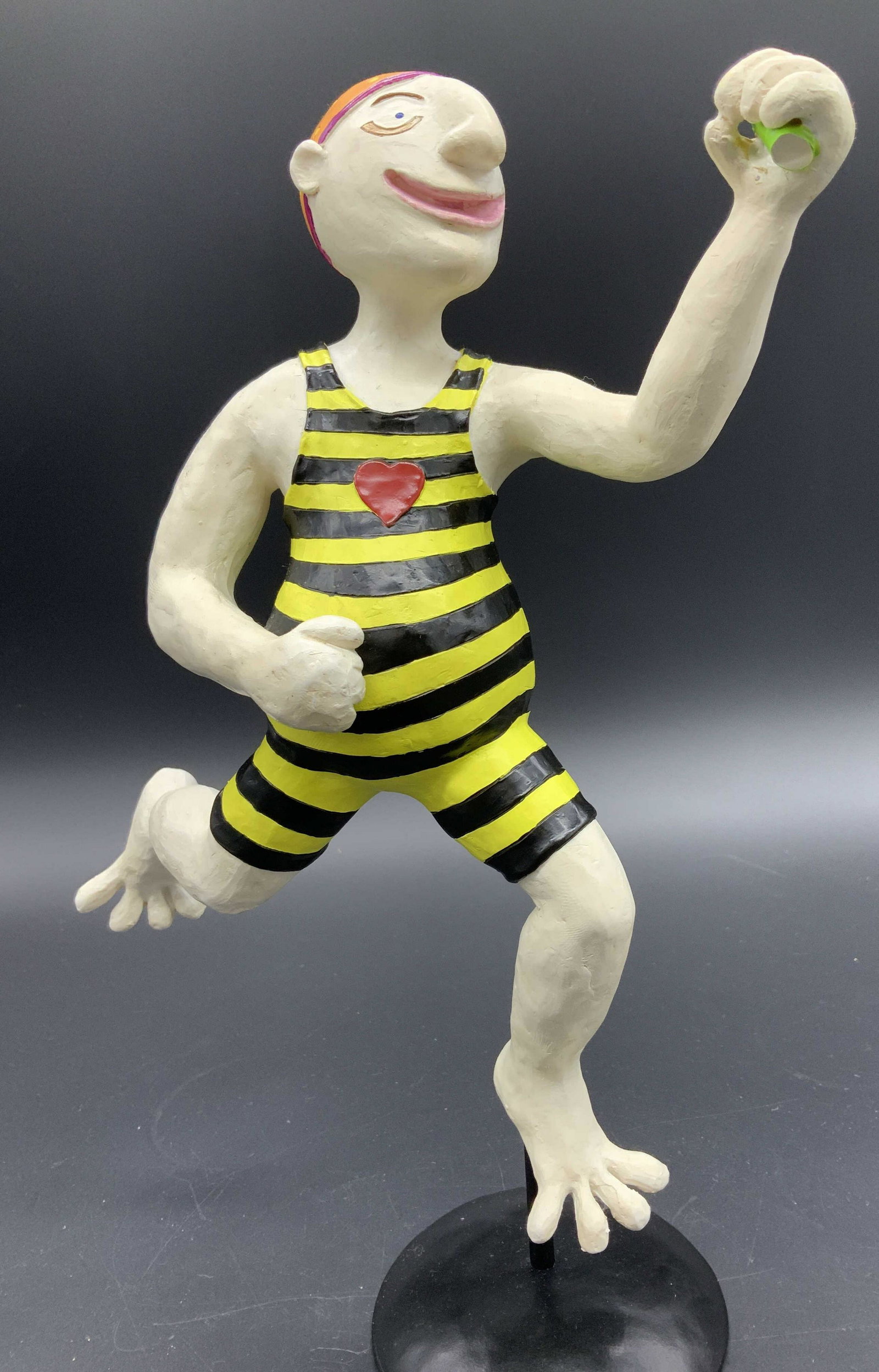 Judie Bomberger Dubow Signed Male Bather Figural: Artisanal Stauette/ Figural signed by maker Judie Bomberger Dubow on verso of metal stand. Composite male wearing yellow and black swimsuit with red heart on chest, orange bathing cap . Whimsical char