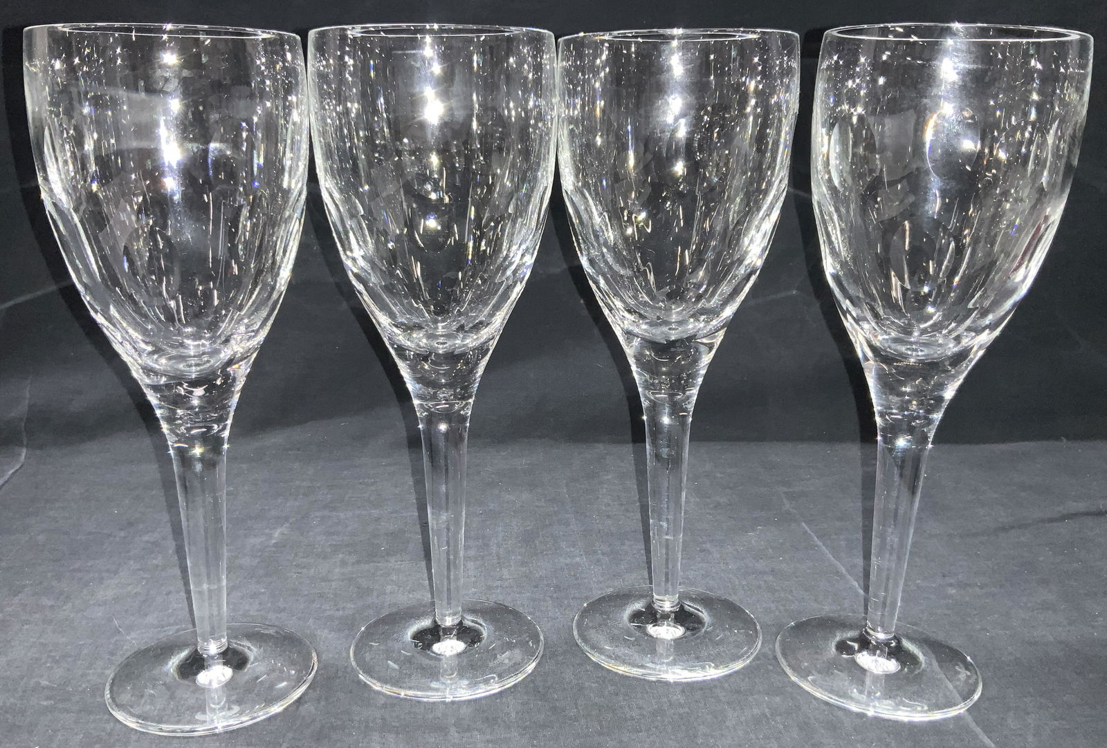 4 JOHN ROCHA WATERFORD Crystal Stemware: Set of 4 crystal crafted stemware cups with thick glass stems and flat bases. Cups have oval shaped vertical sections cut into the cups. Approximately 9 inches tall. Underside is marked JOHN ROCHA WAT