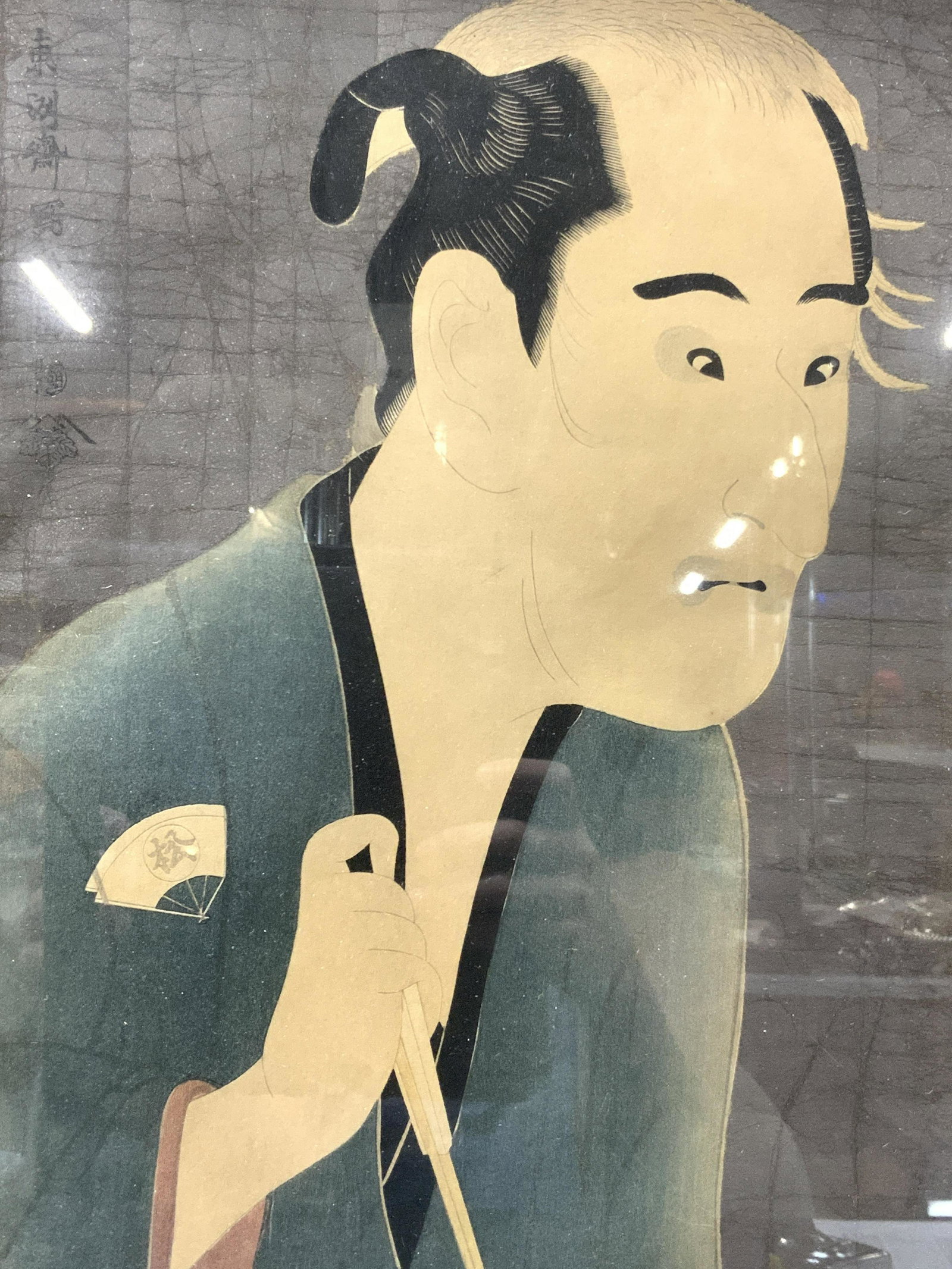 ATTR SHARAKU Mixed Media Hand Colored Engraving: Signed on upper right corner with Sharaku Signature, subject depicts a samurai in blue robes holding a white toned fan in one hand. Please Note: All lots that do not carry established documented prove