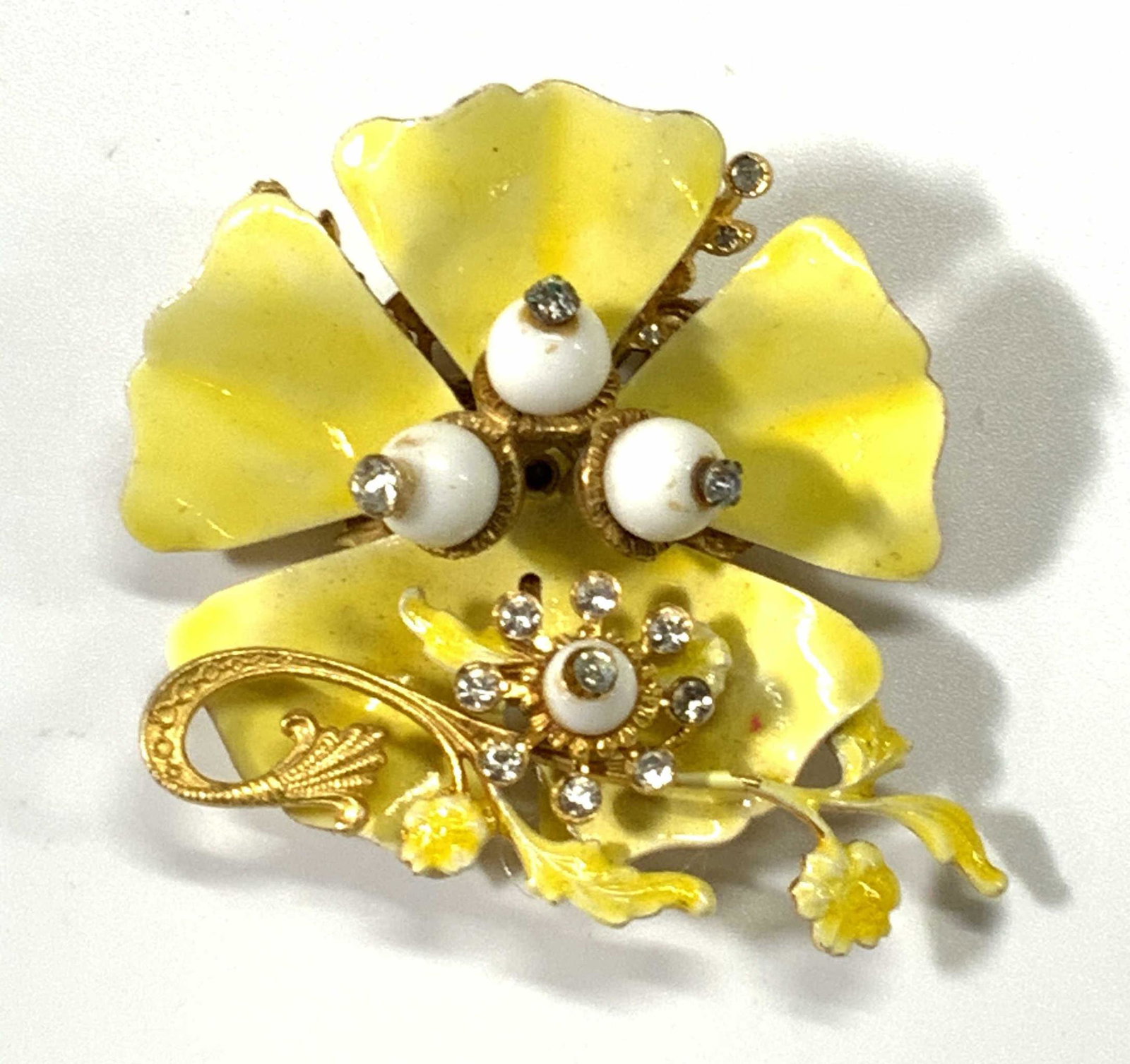 Vintage HATTIE CARNEGIE Yellow Floral Brooch: Vintage Hattie Carnegie floral form brooch with white beads and colorless bezel set faceted crystals. Gold tone metal with yellow enamel. Hinge pin to underside. Designer trademark to underside. Measu