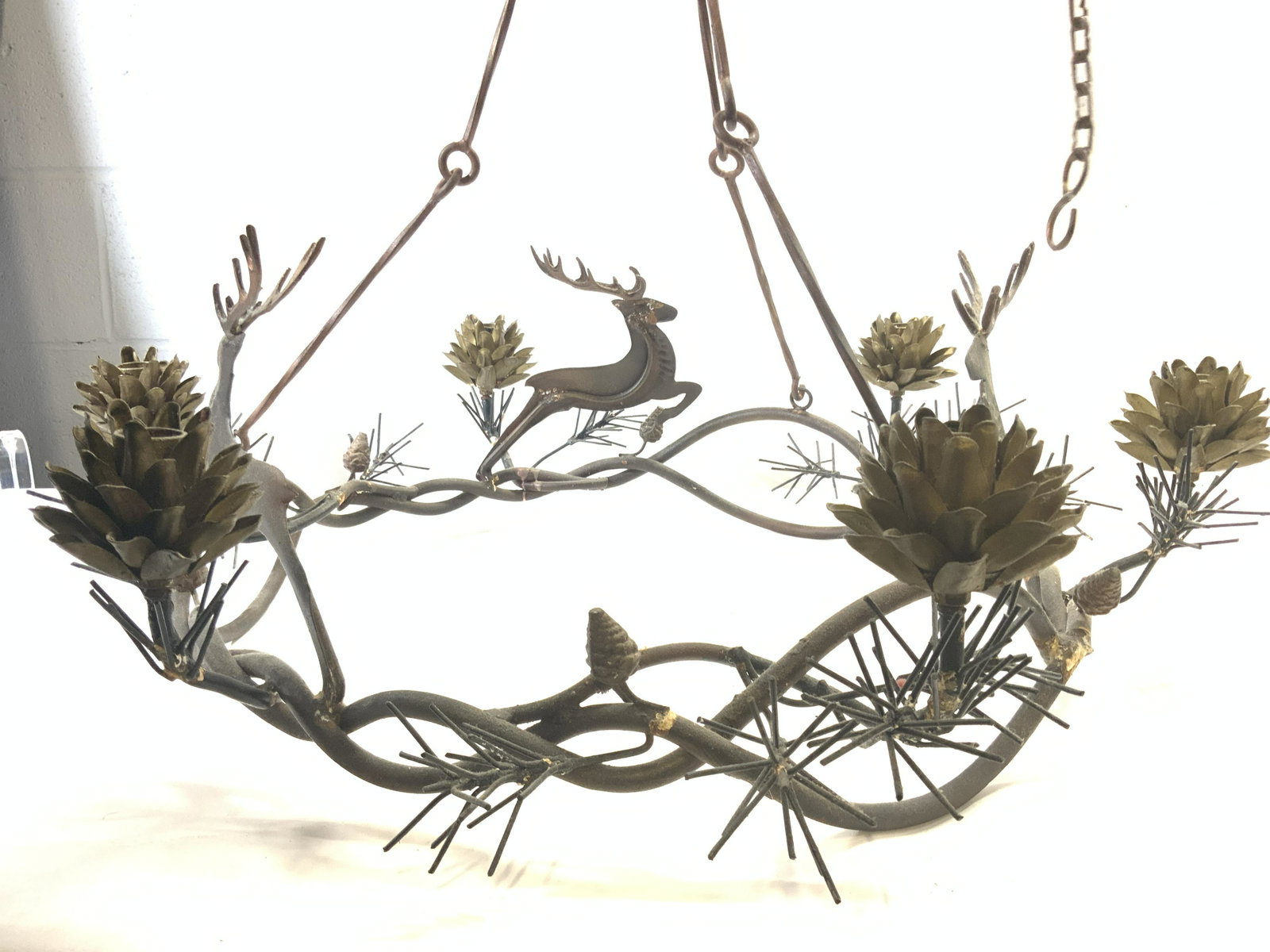 Holiday Reindeer Pinecone Iron Ceiling Candelabra: Candelabra/ chandelier is metal, appears to be iron. Piece has 3 reindeer figures & 6 pinecone candle areas. Piece also has pine needle & twisted vine detail. Piece measures approx 30 inches wide 23 i