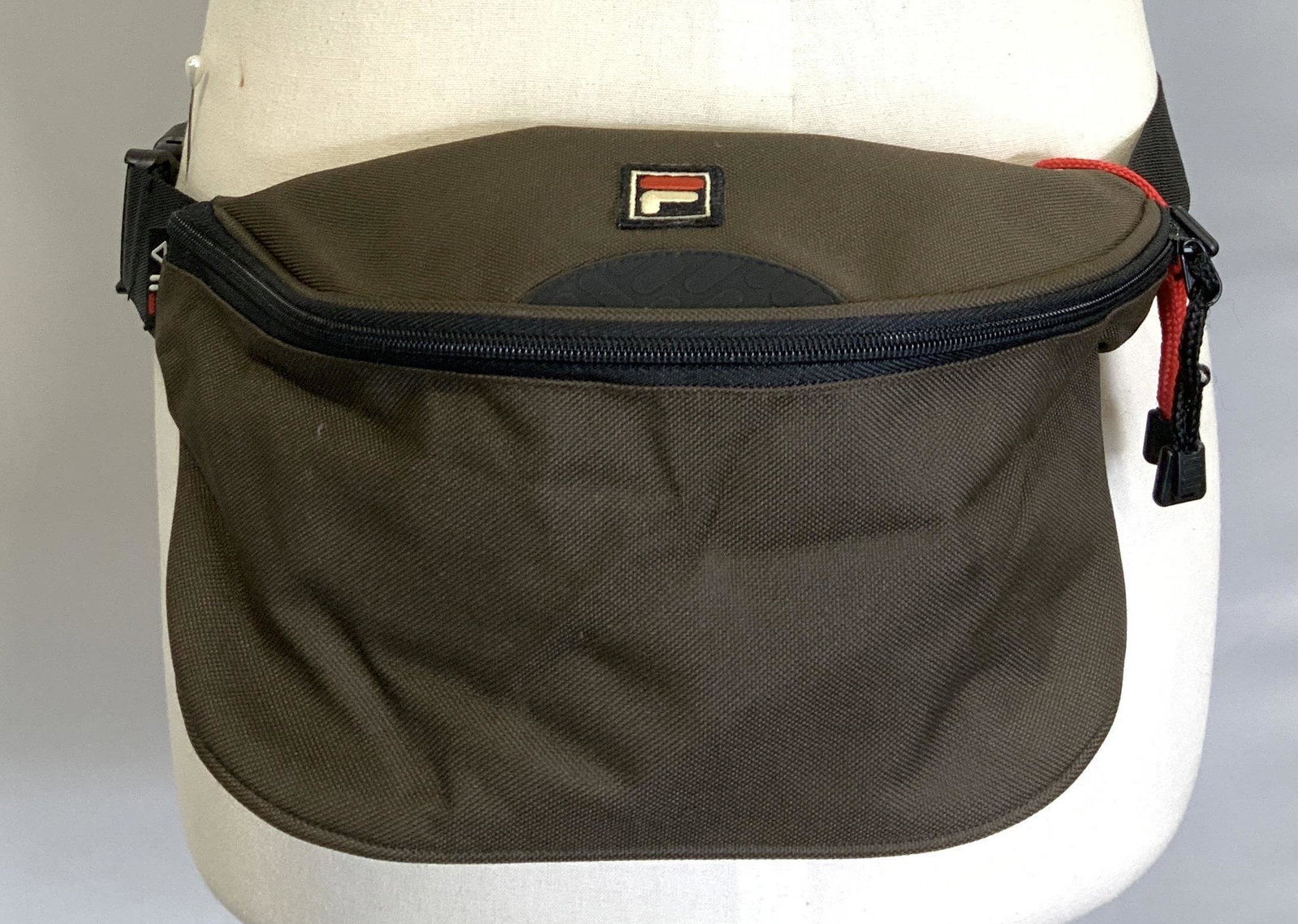 FILA CANVAS FANNY PACK: Brown canvas FILA Fanny pack , adjustable waist to 41 in., bag measures 11 in. Long, 6.5 in. Deep, 8 in ht. Backside zipper compartment. Possibly new. 3 Unisex accessories, FILA canvas Fanny pack, hik