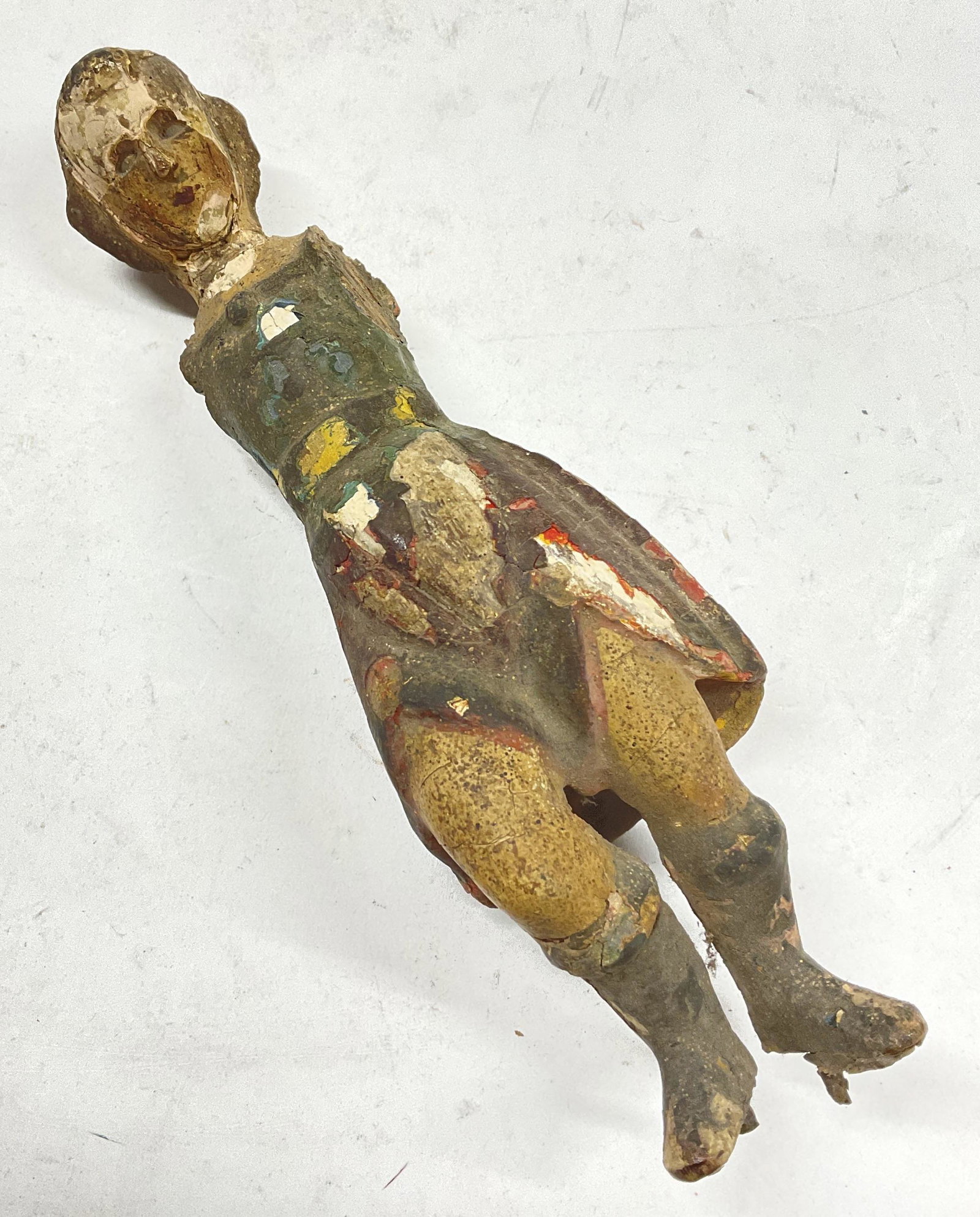 Carved Wood Antique Figurine of Man: Carved Wood Antique Figurine of Man. 2 prongs to feet, could have been part of a sculpture, clock of altar. Prior reparation to piece. Coating is chipping and coming off. Needs repair. Definite wear t