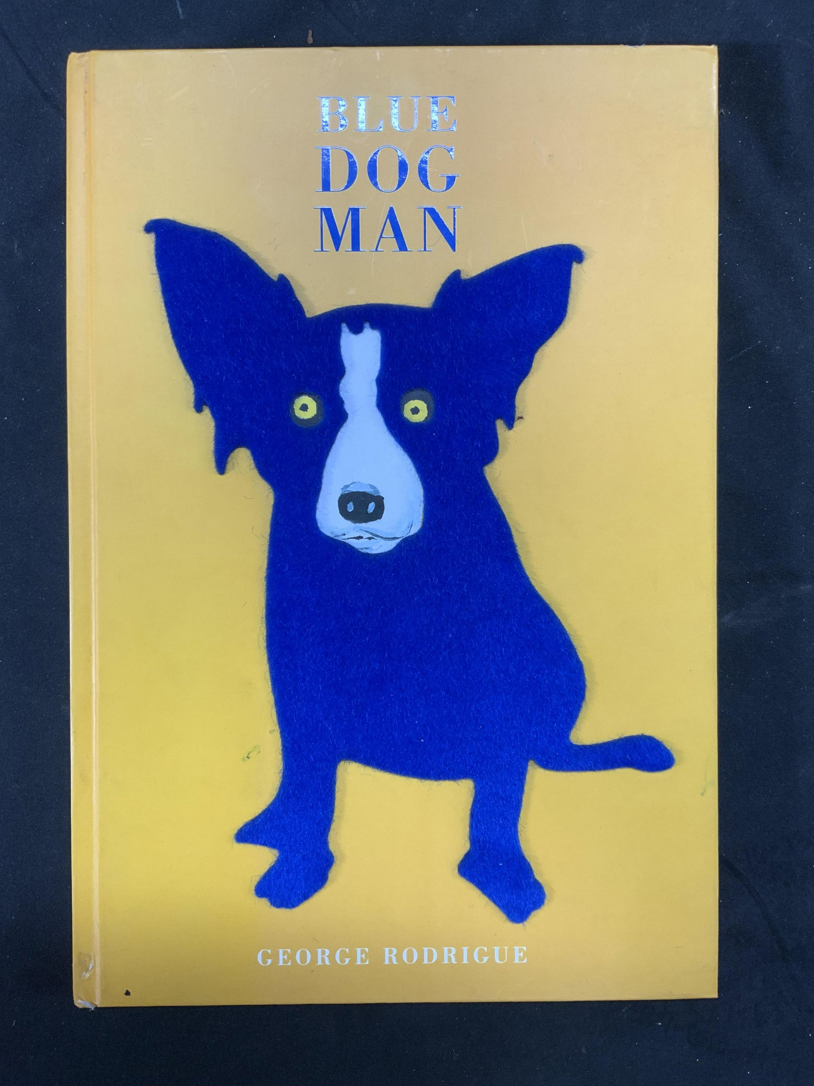 Blue Dog Man by George Rodrigue: Hardcover copy of Blue Dog Man by George Rodrigue. Published by Stewart, Tablri, and Chang, 1999. Some wear to book consistent with exposure. Damage to corner. Measures approx 12 1/2 in by 8 1/2 in. G